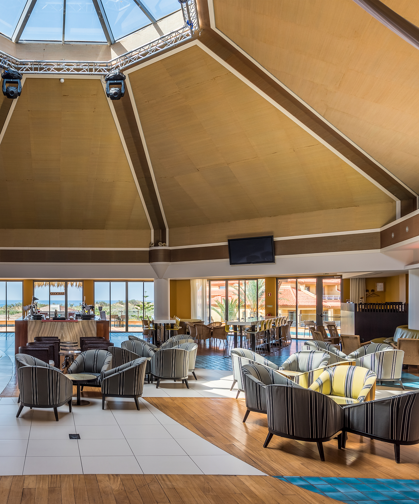 Espaço de eventos em Hotel com Tudo Incluído e Spa no Porto Santo, com várias mesas e cadeiras, janelas e muita luz natural