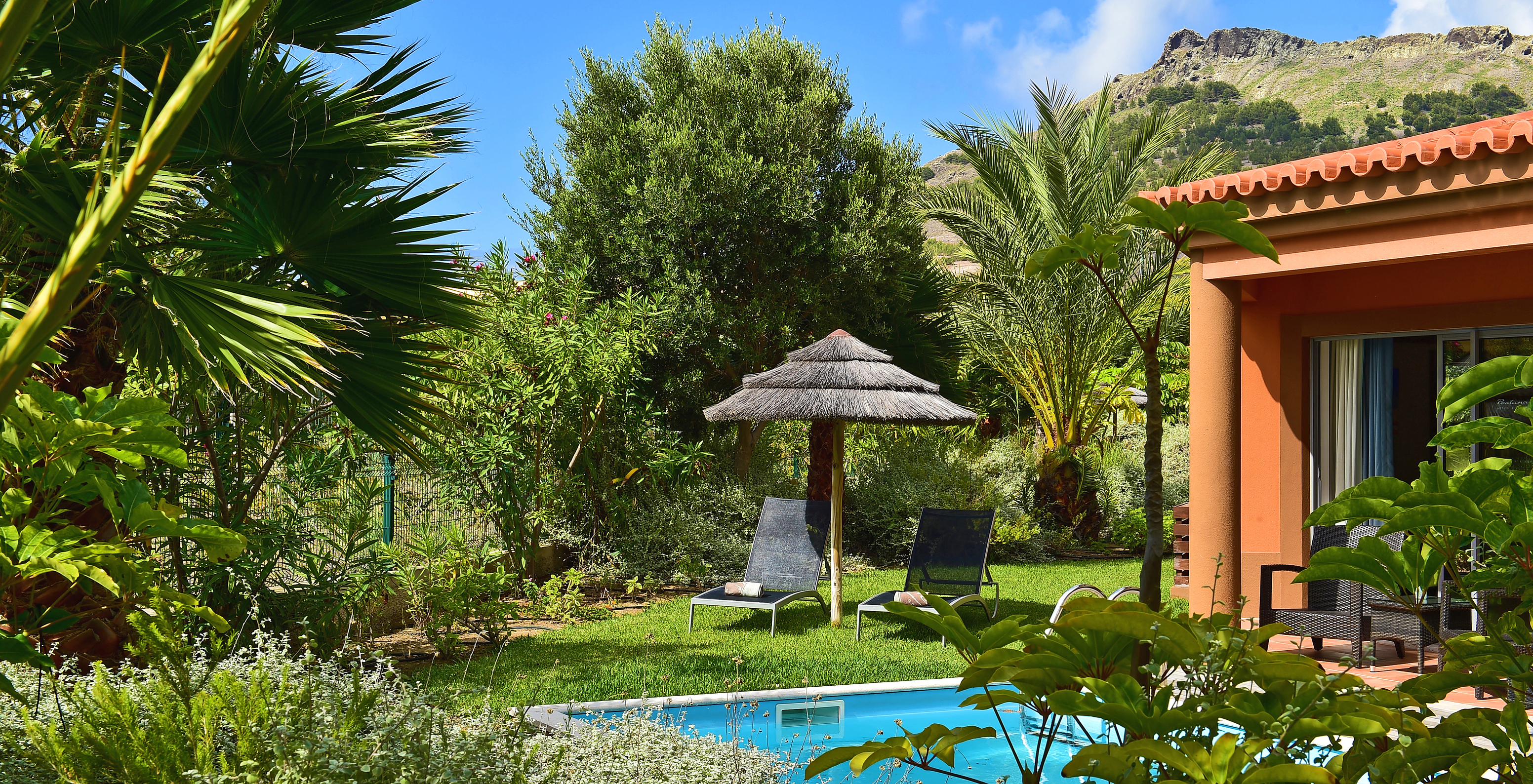 A Pool Villa do Pestana Porto Santo All Inclusive tem uma piscina privada, espreguiçadeiras e um chapéu de palha