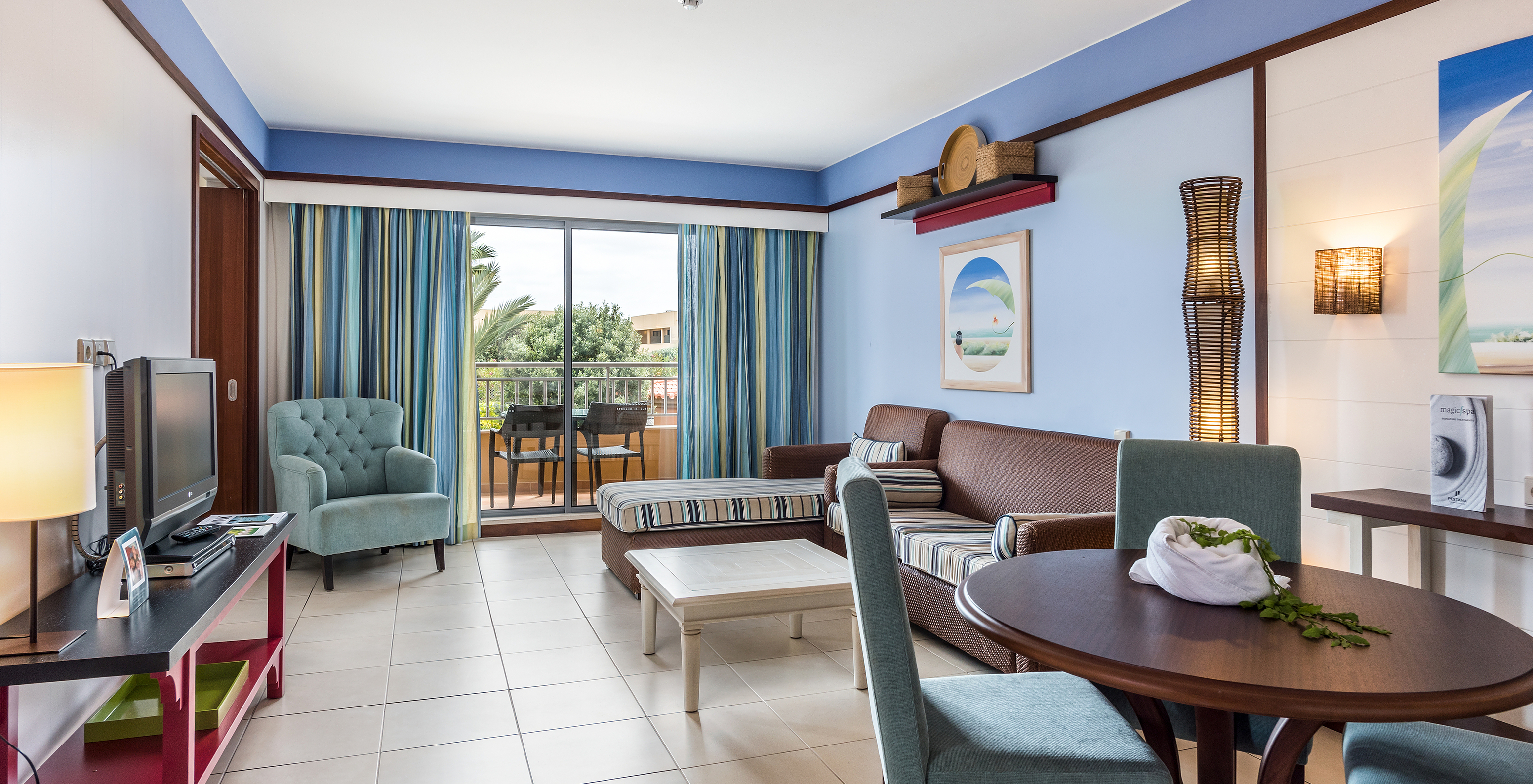 A Suite Apartamento T2 do Pestana Porto Santo All Inclusive tem uma sala com dois sofás, televisão e acesso à varanda