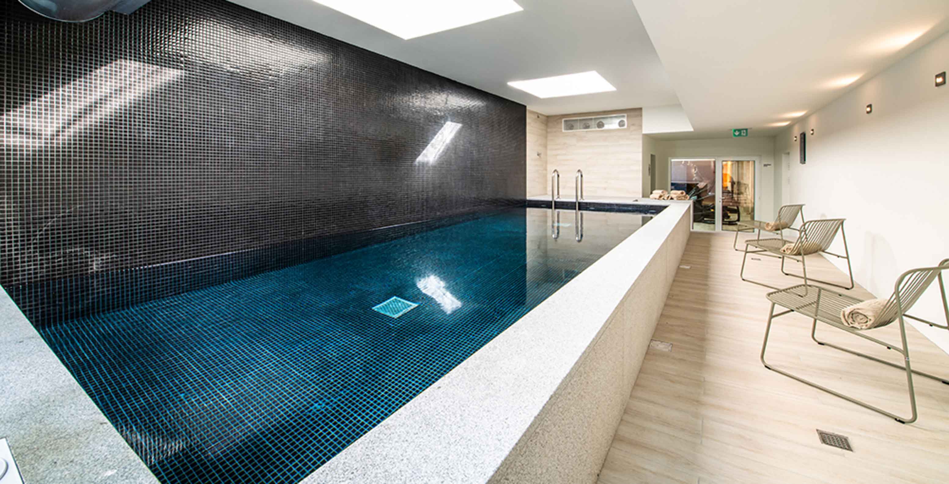 Piscina interior do Pestana Douro Riverside, Hotel com Piscina em Frente ao Rio Douro, com cadeiras e toalhas