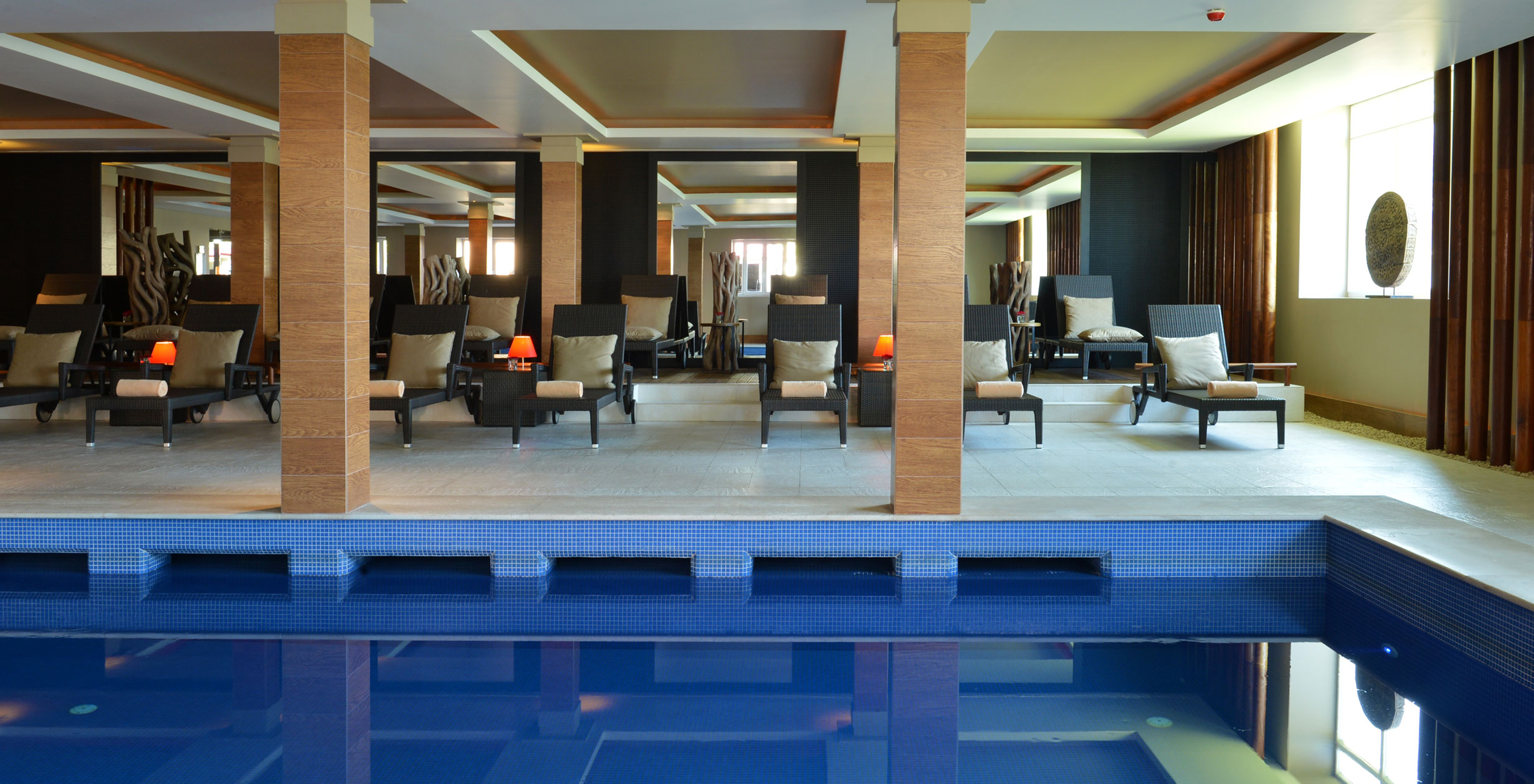 Piscina interior do Pestana Palácio do Freixo, Hotel no Rio Douro com Spa e Piscina, com espreguiçadeiras com almofadas