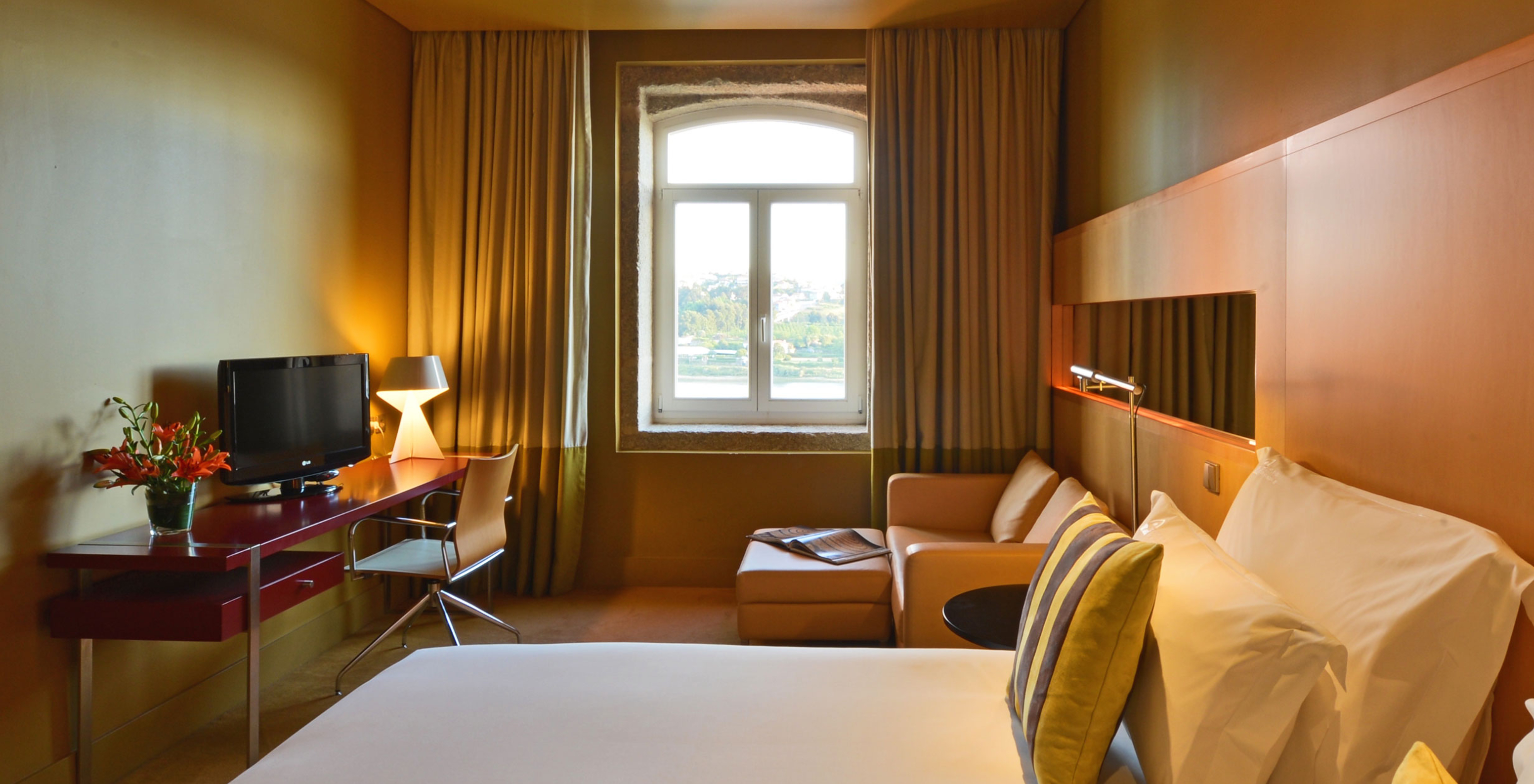 O Executive Superior do Pestana Palácio do Freixo tem uma cama de casal, uma janela com peitoril em pedra e um sofá