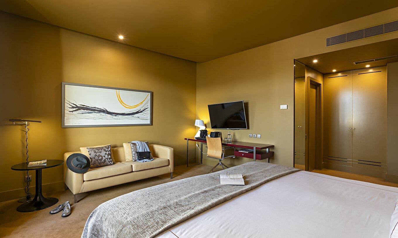 O Executive do Pestana Palácio do Freixo tem um cama de casal, um sofá, uma tv e uma secretária