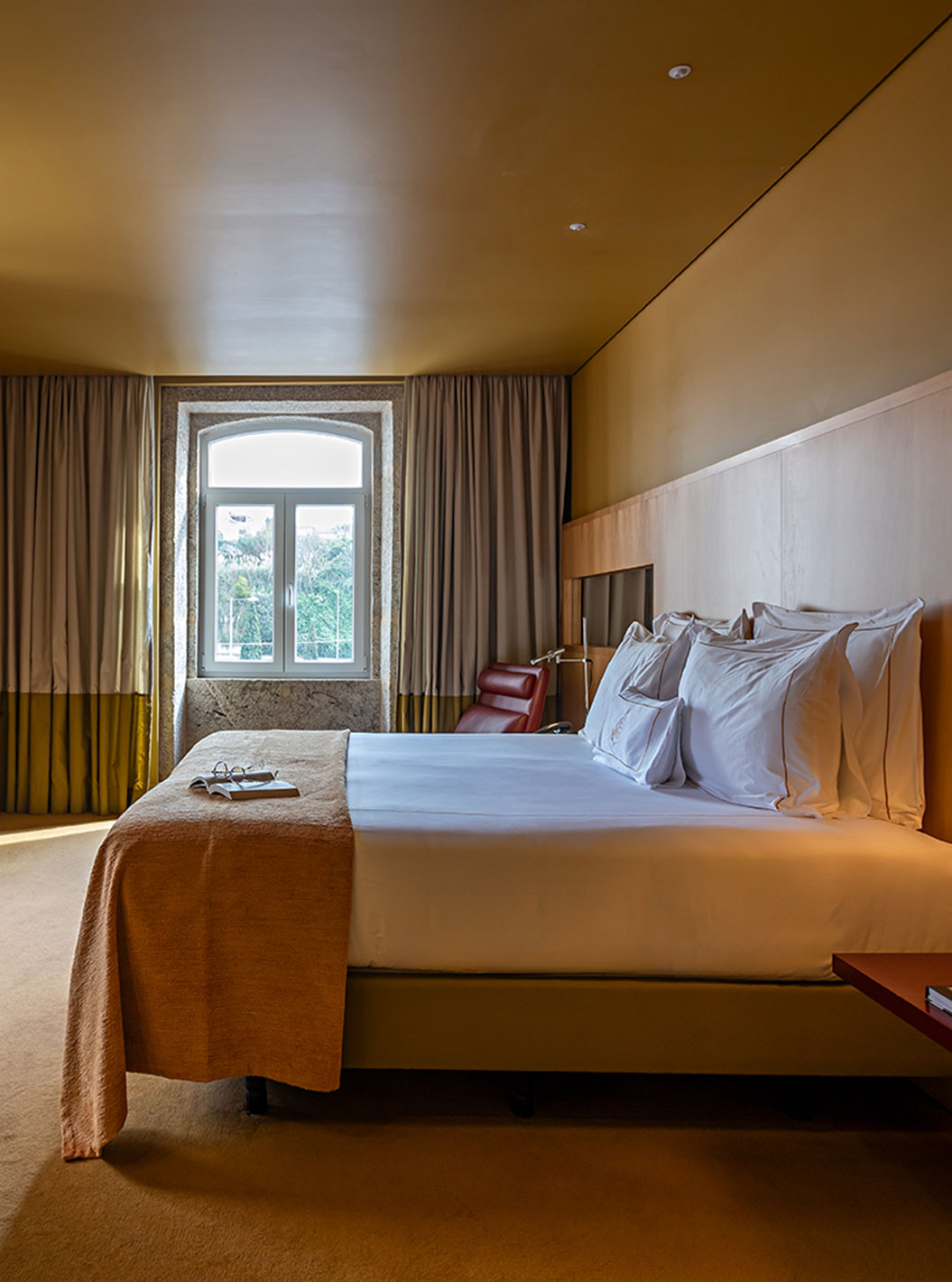 Junior Suite do Pestana Palácio do Freixo com cama ampla, janelas altas, cortinas elegantes e iluminação suave