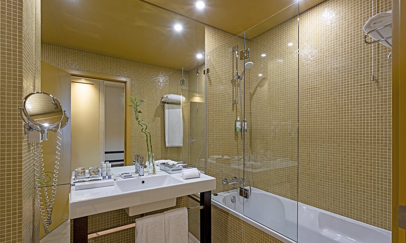 O Superior do Pestana Palácio do Freixo tem uma casa de banho com azuleijos amarelos com lavatório e banheira