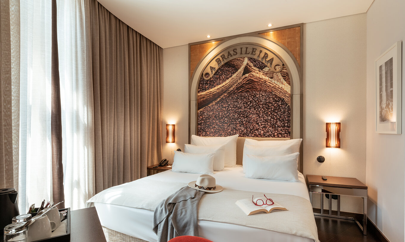 O Deluxe do Pestana Porto - A Brasileira tem uma cama de casal com um mural temático na cabeceira da cama