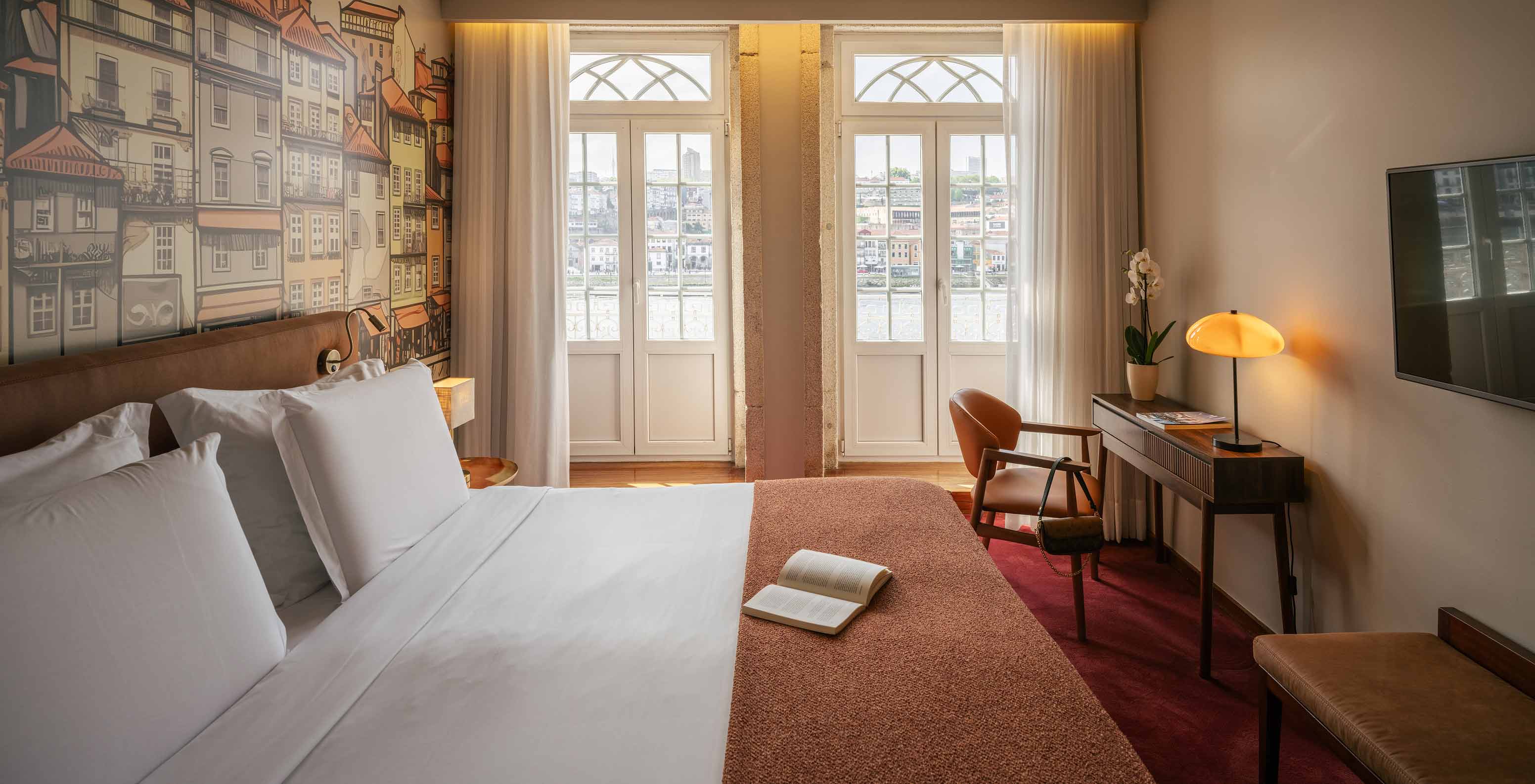 Pestana Vintage Porto, Hotel 5 Estrelas no Centro do Porto, com quarto iluminado e varanda sobre o rio