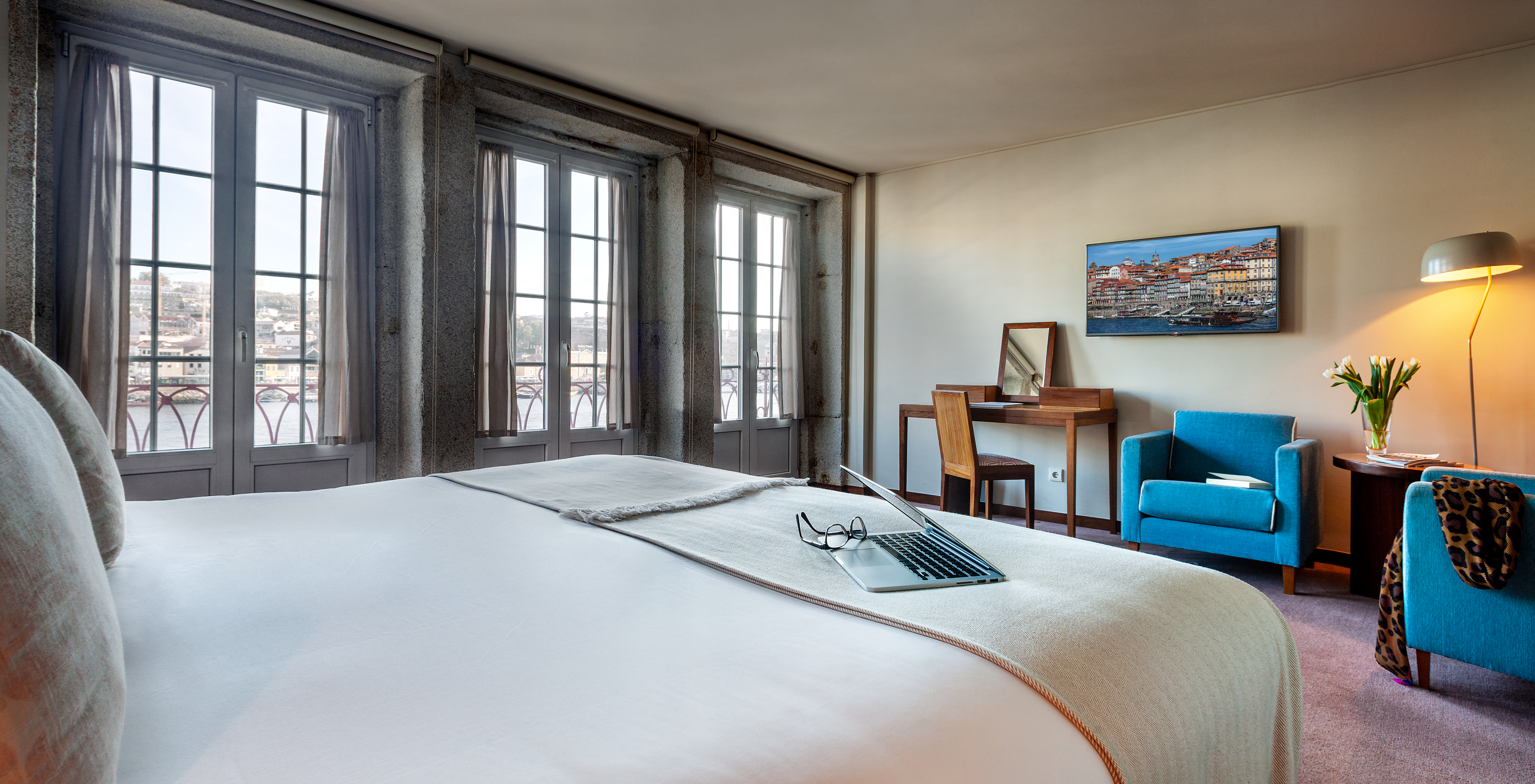 A Suite Grand View do Pestana Vintage Porto tem uma cama de casal, três grandes janelas com vista para o rio Douro