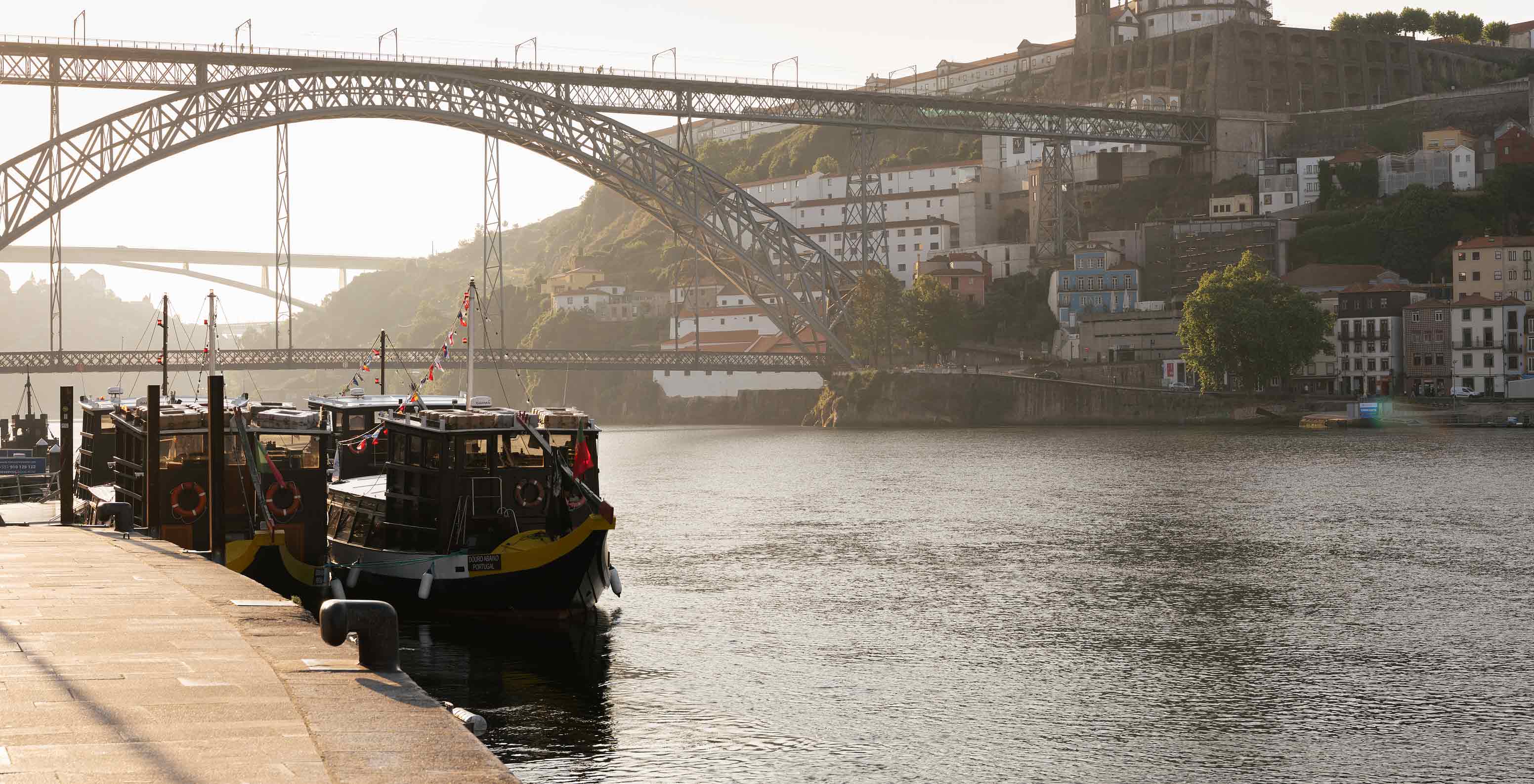 Pestana Vintage Porto Hotel na Praça da Ribeira, no Porto, com vista para barcos no rio e Ponte Dom Luís