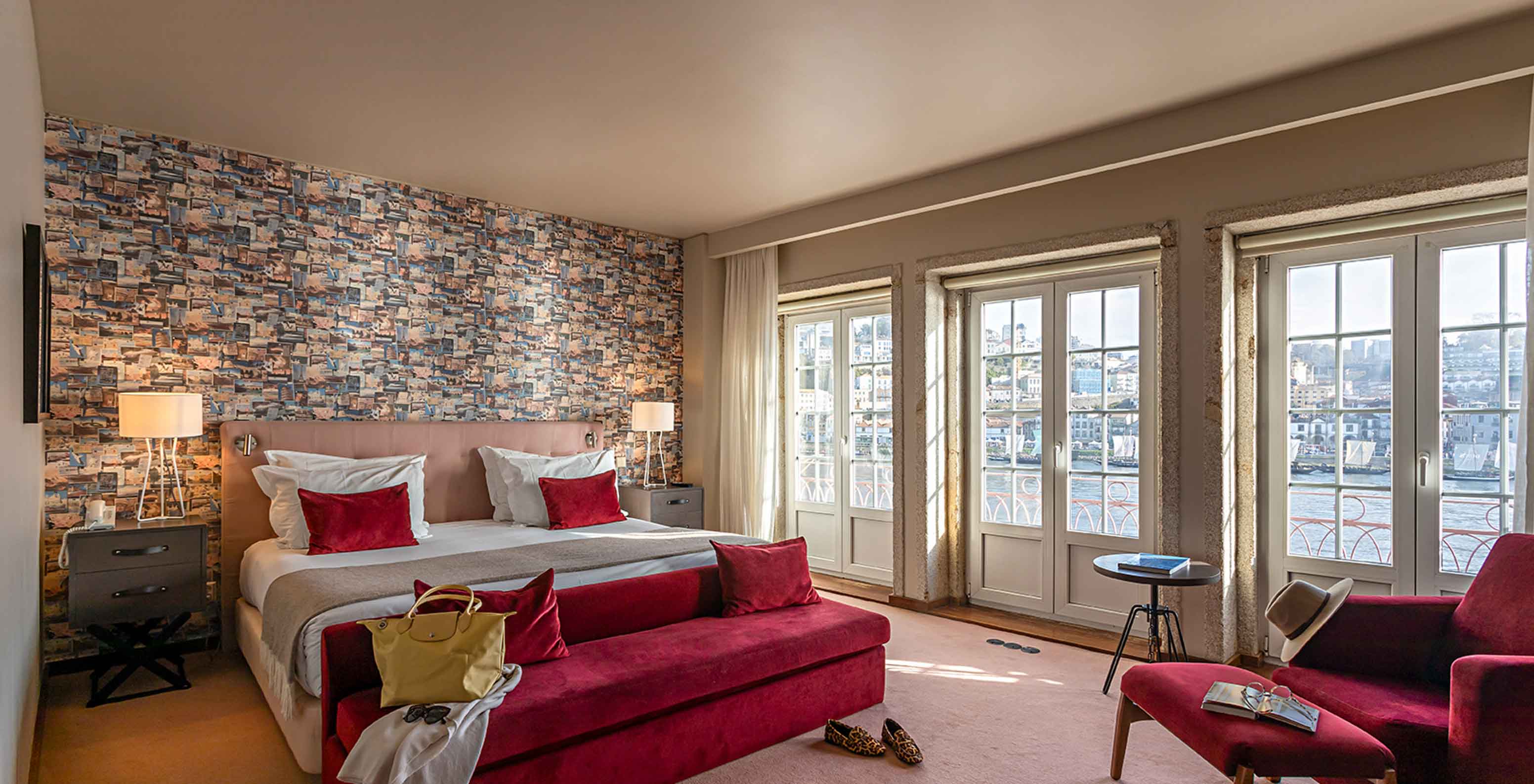 A Suite Grand View do Pestana Vintage Porto tem uma cama de casal, com papel de parede com imagens de viagens e sofás