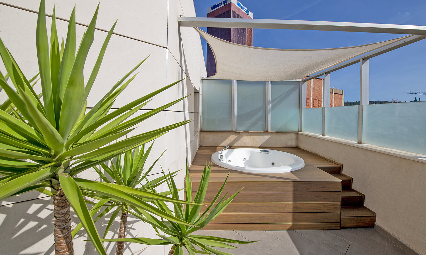 A Junior Suite com Jacuzzi no Terraço do Pestana Arena Barcelona tem um terraço com um jacuzzi, cadeiras e plantas