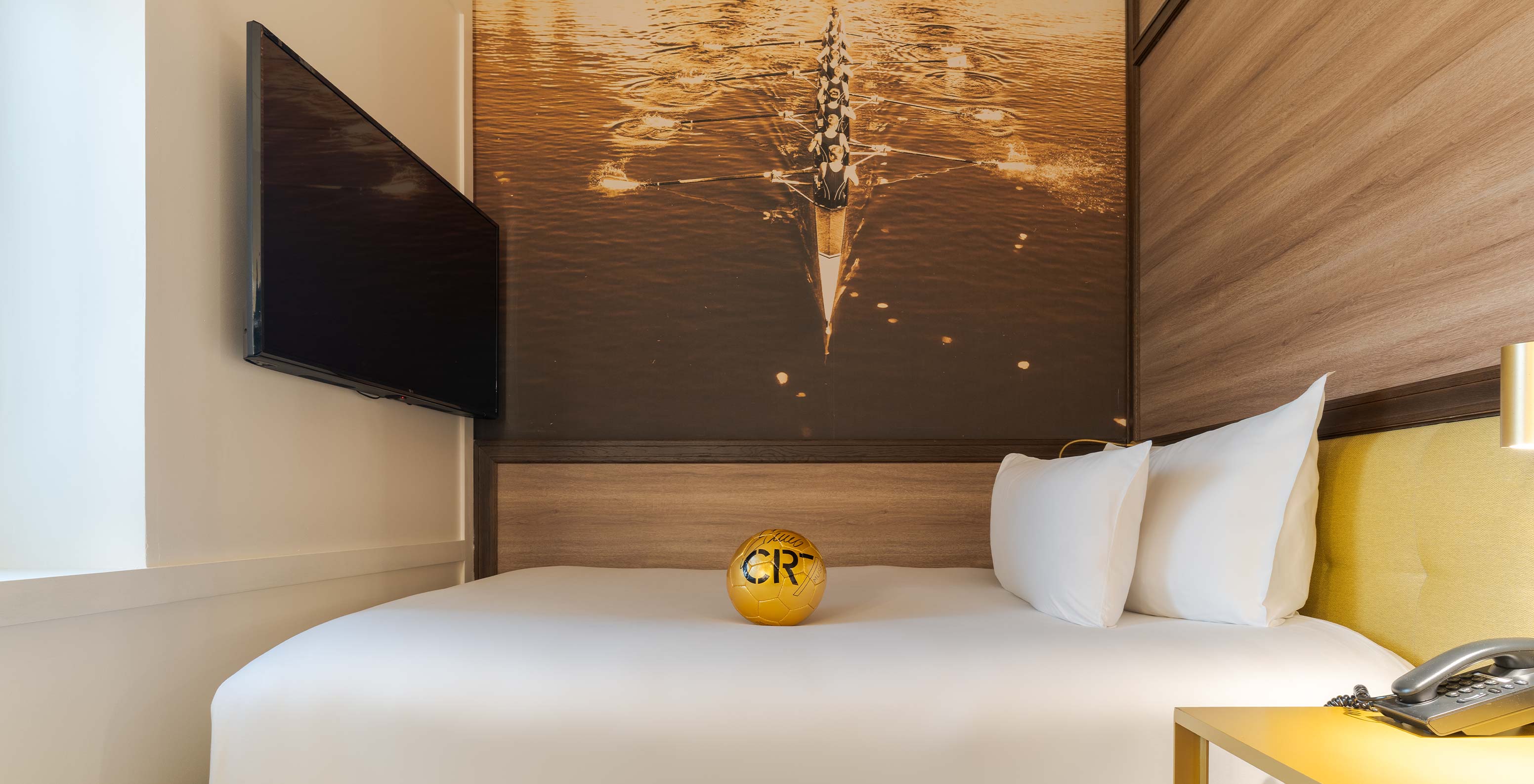 Quarto Cozy no Pestana CR7 Gran Vía Madrid com cama branca, bola dourada CR7 e fotografia náutica na parede