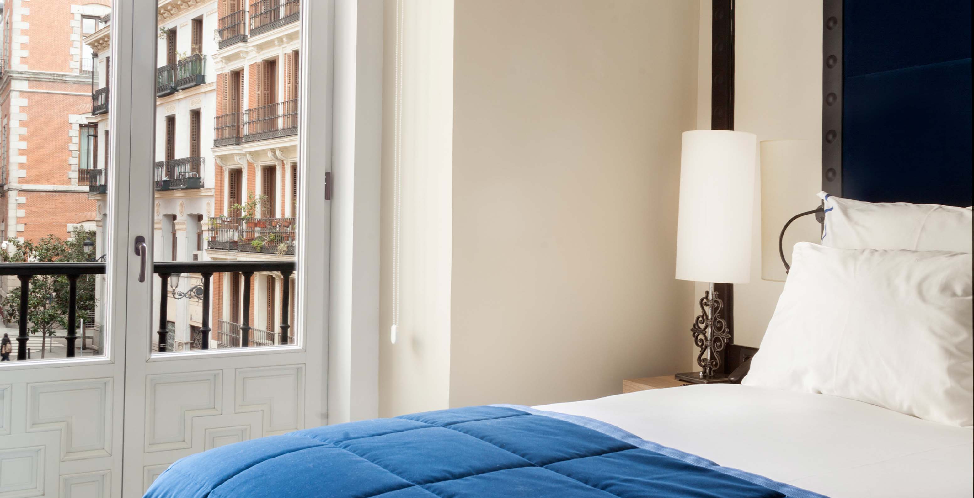 O Superior Plaza Mayor do Pestana Plaza Mayor Madrid tem uma cama, um candeeiro na mesa de cabeceira e uma janela