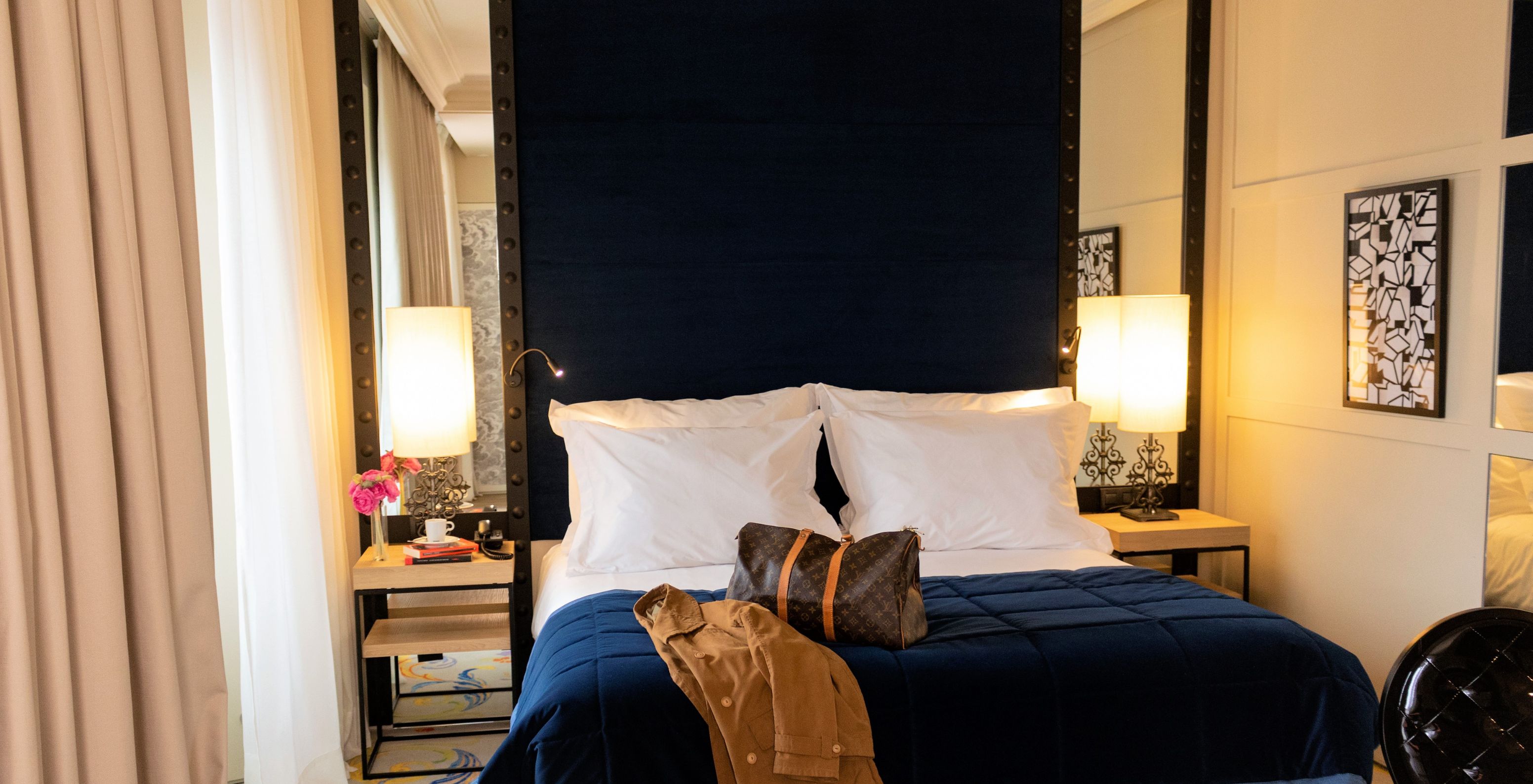 O Quarto Superior Plus do Pestana Plaza Mayor Madrid tem uma cama de casal com uma mala e um casaco em cima da cama