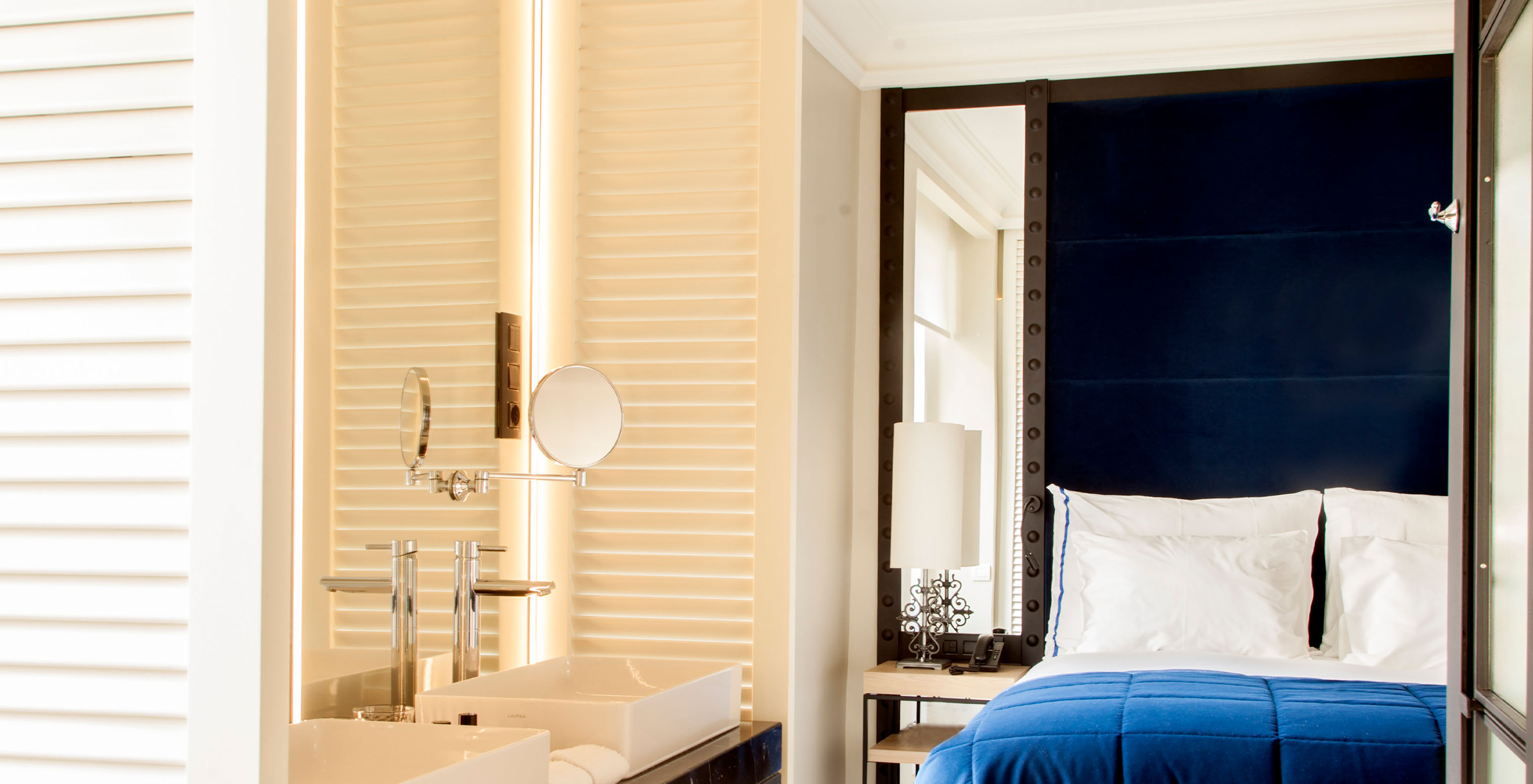 O Quarto Superior do Pestana Plaza Mayor Madrid tem uma cama de casal com cabeceira azul com espelho e um lavatório