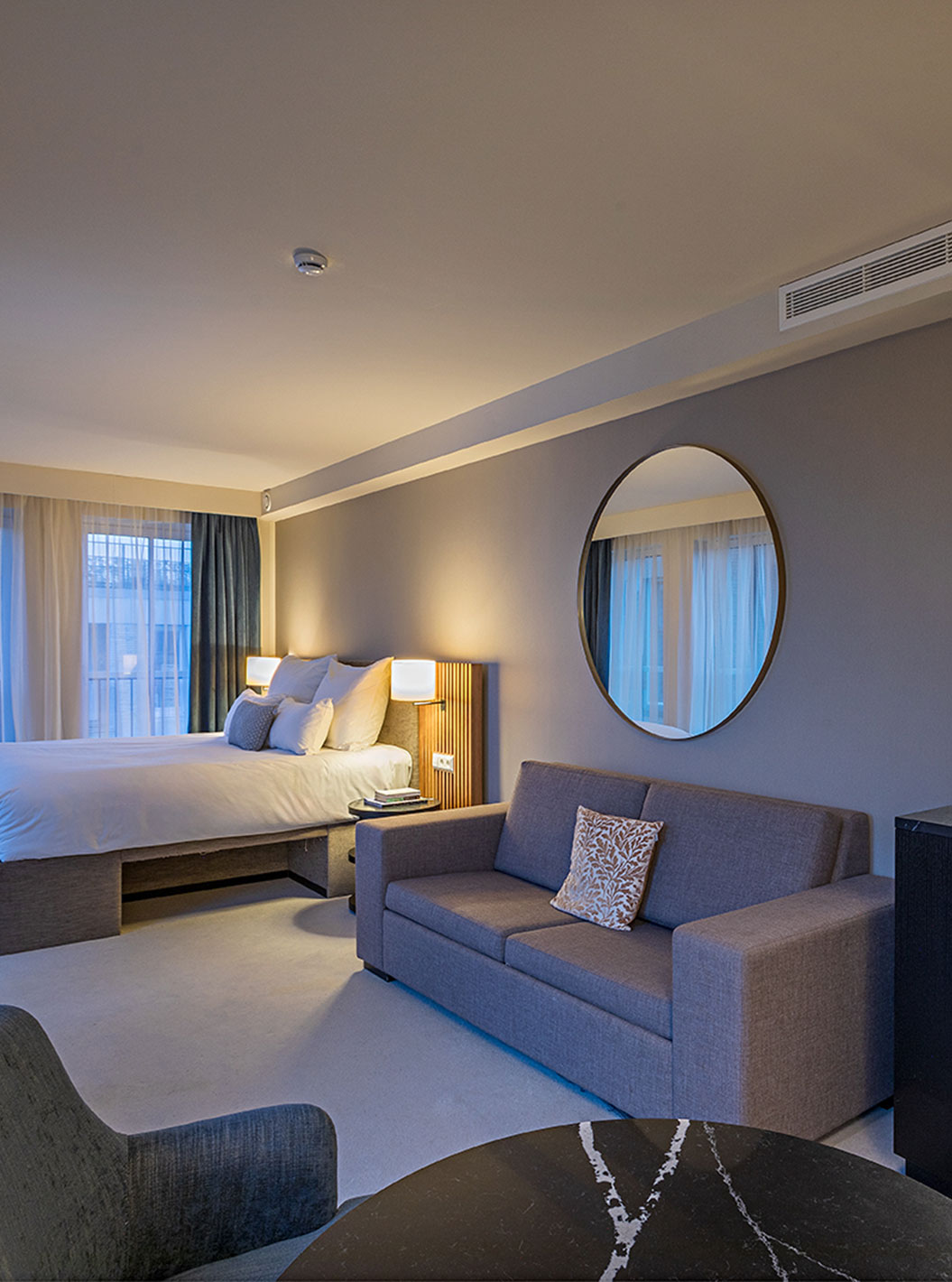 Quarto Comfort Studio do Pestana Amsterdam Riverside com cama de casal, sofá, mesa e kitchenette moderna