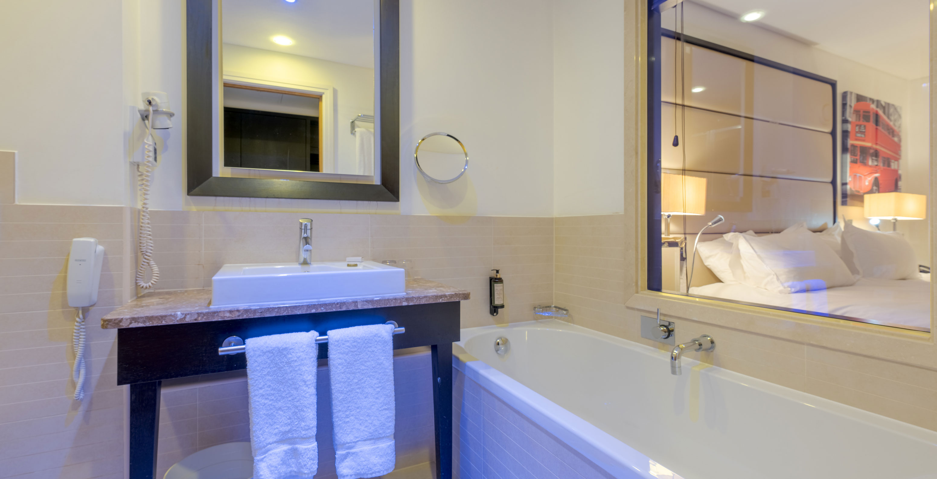 O Superior Twin do Pestana Chelsea Bridge tem casa de banho com banheira, vidro para o quarto, lavatório, espelhos e secador