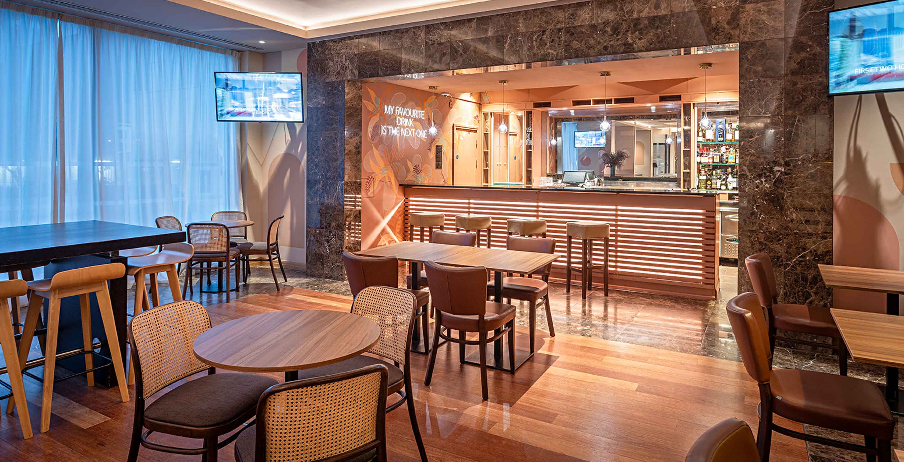 Restaurante do Pestana Chelsea Bridge, Hotel 4 Estrelas em Londres, com mesas em madeira e bar iluminado