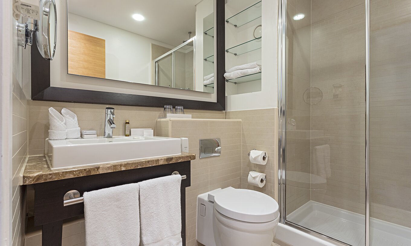 Casa de banho da suíte executiva de um quarto com varanda do Pestana Chelsea Bridge, com lavatório e duche