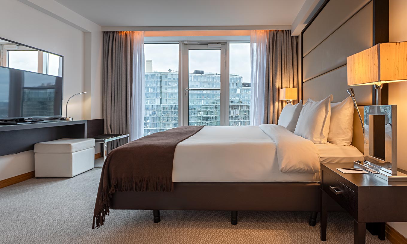 Suite Executiva de Um Quarto no Pestana Chelsea Bridge com cama de casal, janelas amplas e vista urbana