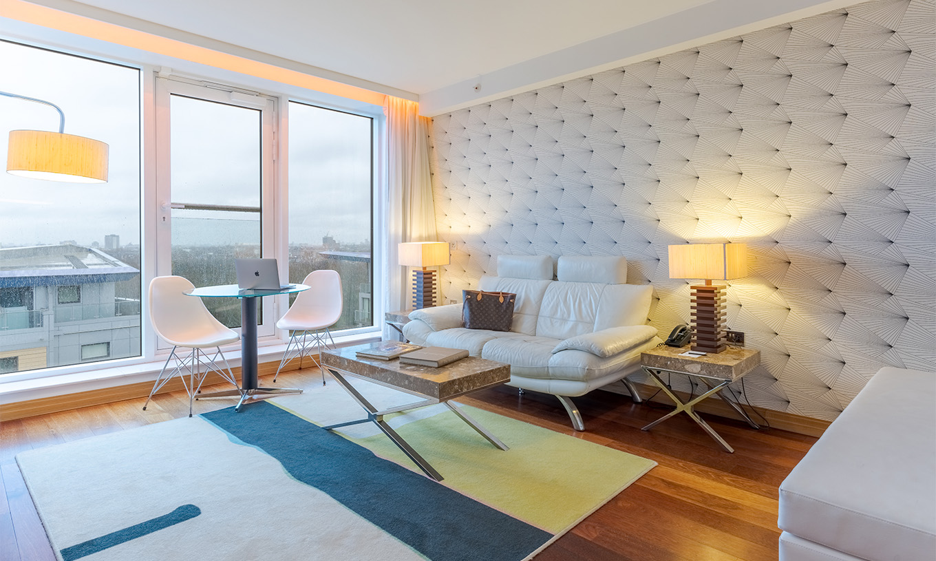 A Suite Executiva com 1 Quarto e Varanda do Pestana Chelsea Bridge tem um sofá com mesa de centro, mesa com cadeiras e janela grande