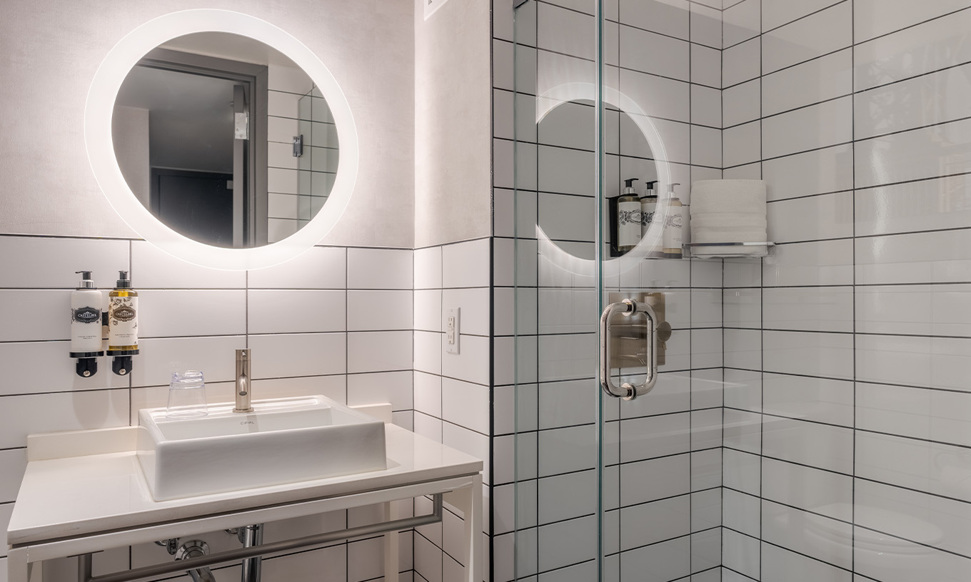 O Comfort Double do Pestana CR7 Times Square tem uma casa de banho com duche, lavatório e um espelho