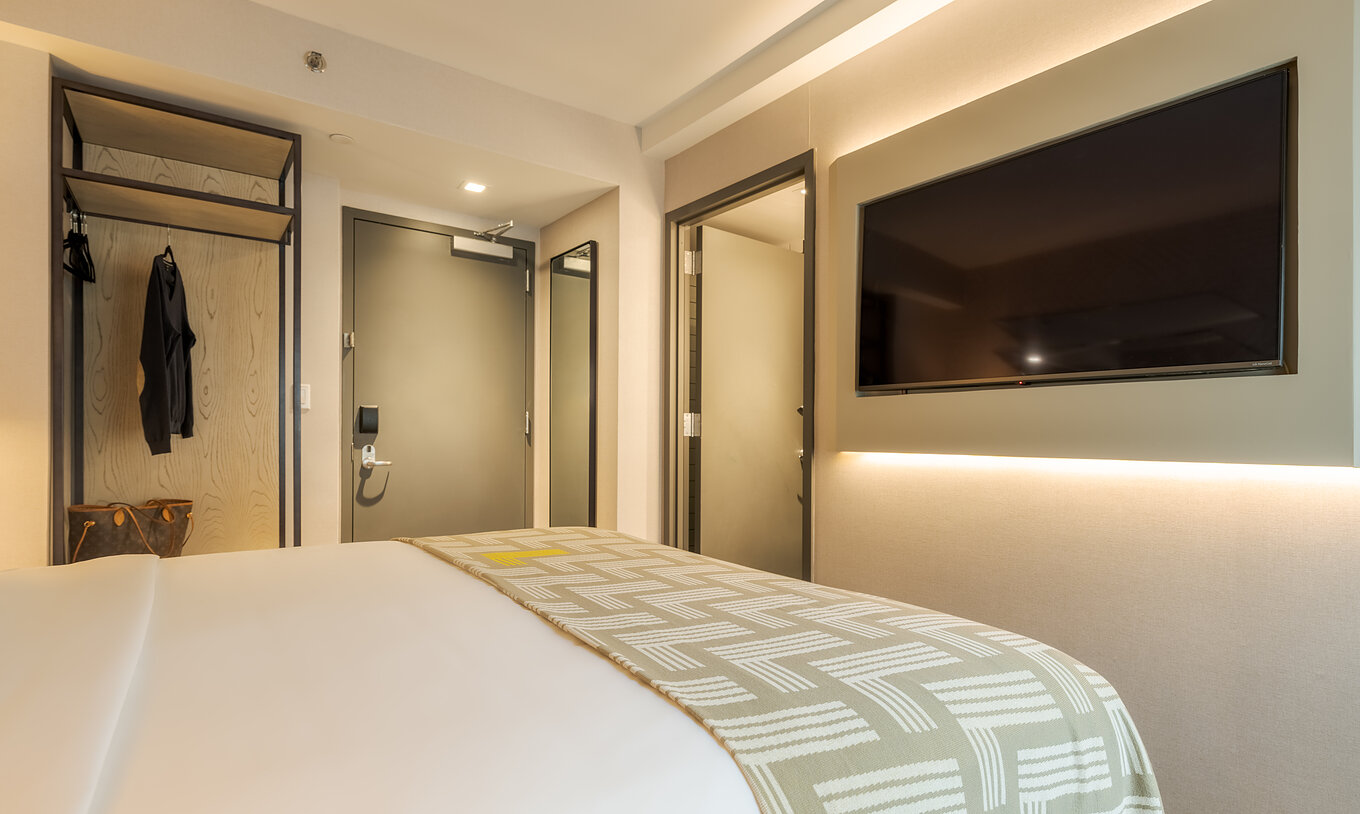 O Comfort ADA do Pestana CR7 Times Square tem uma cama de casal com uma colcha com o número sete e uma televisão