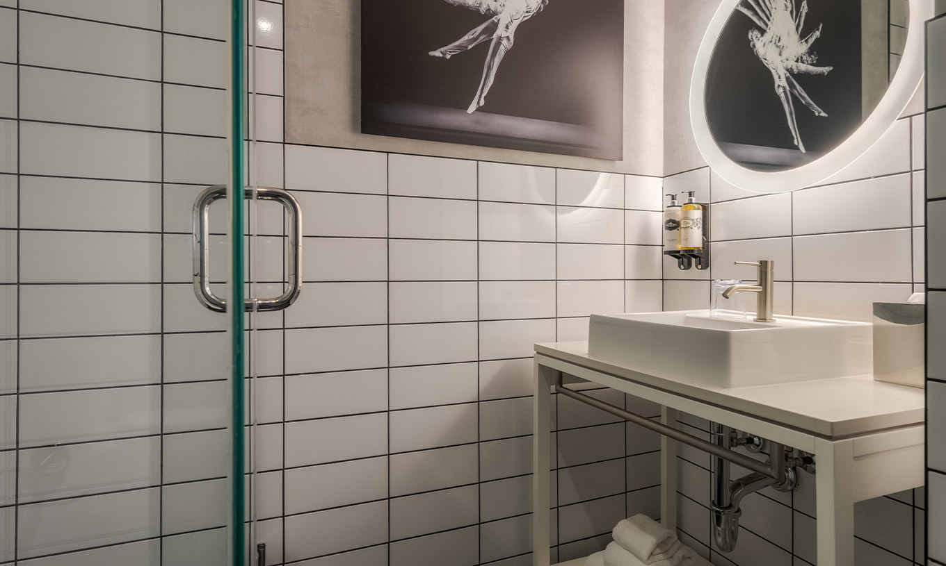 O Comfort Room do Pestana CR7 Times Square tem uma casa de banho com duche, lavatório um espelho e um quadro