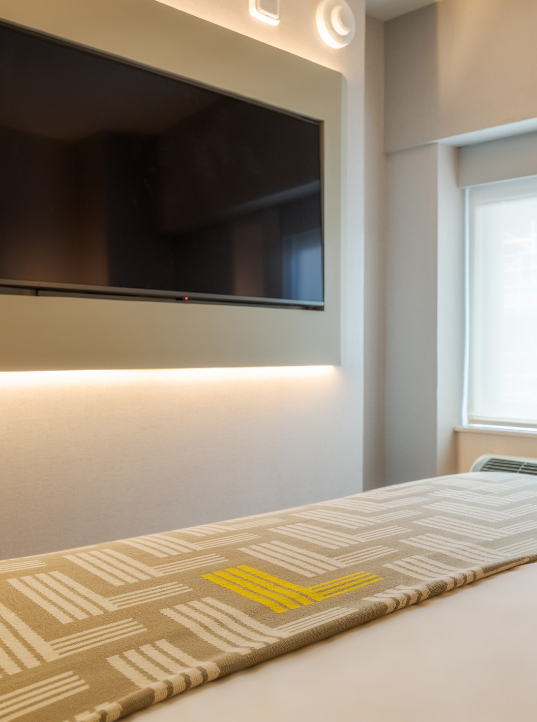 O Comfort Room do Pestana CR7 Times Square tem uma cama de casal com uma colcha com o número sete, uma televisão e uma janela