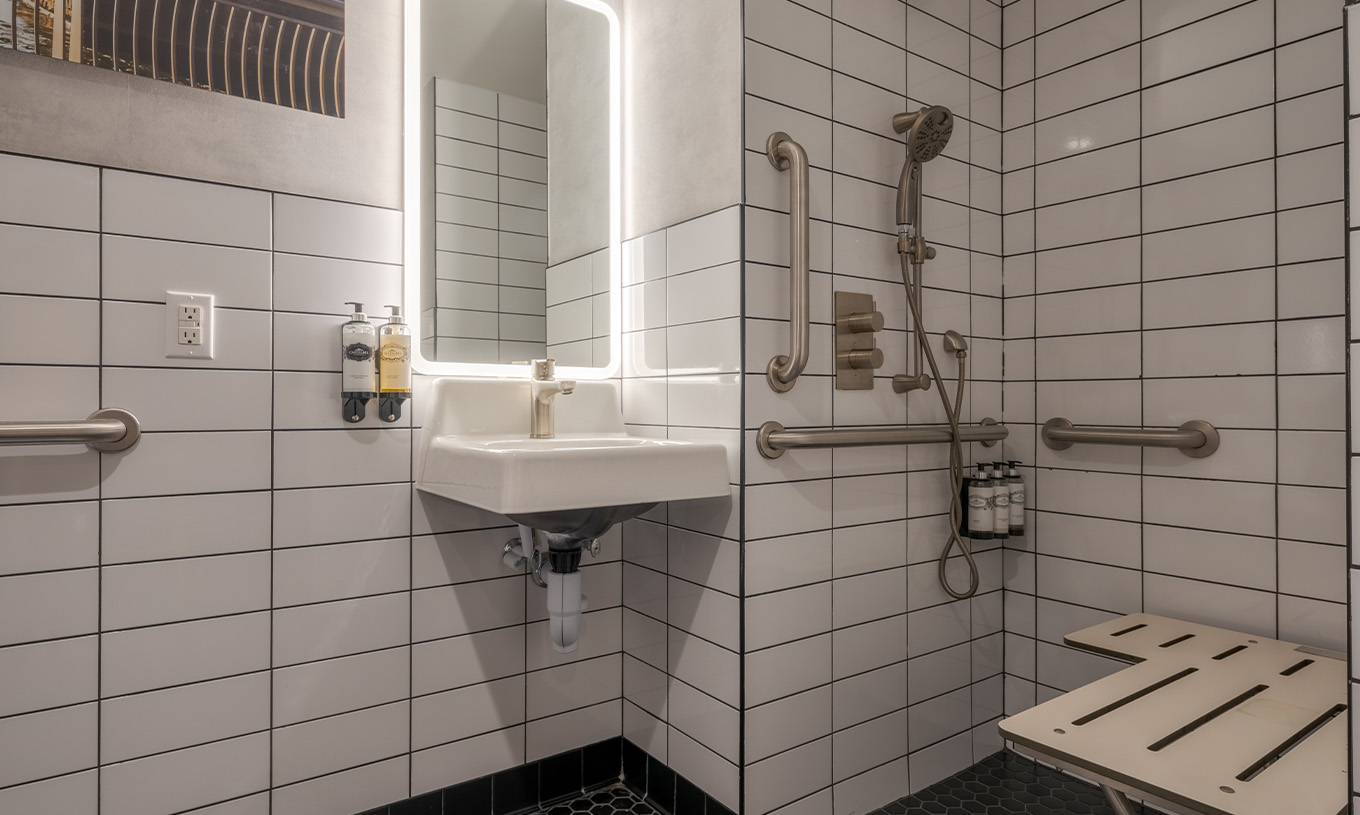 O Superior Double ADA do Pestana CR7 Times Square tem uma casa de banho adaptada com duche, lavatório, e espelho