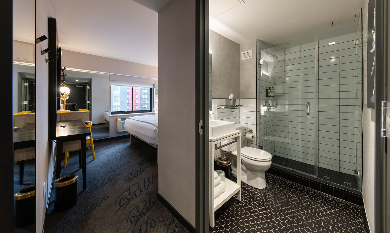 O Superior King High Floor do Pestana CR7 Times Square tem uma casa de banho dentro do quarto e uma janela ao fundo