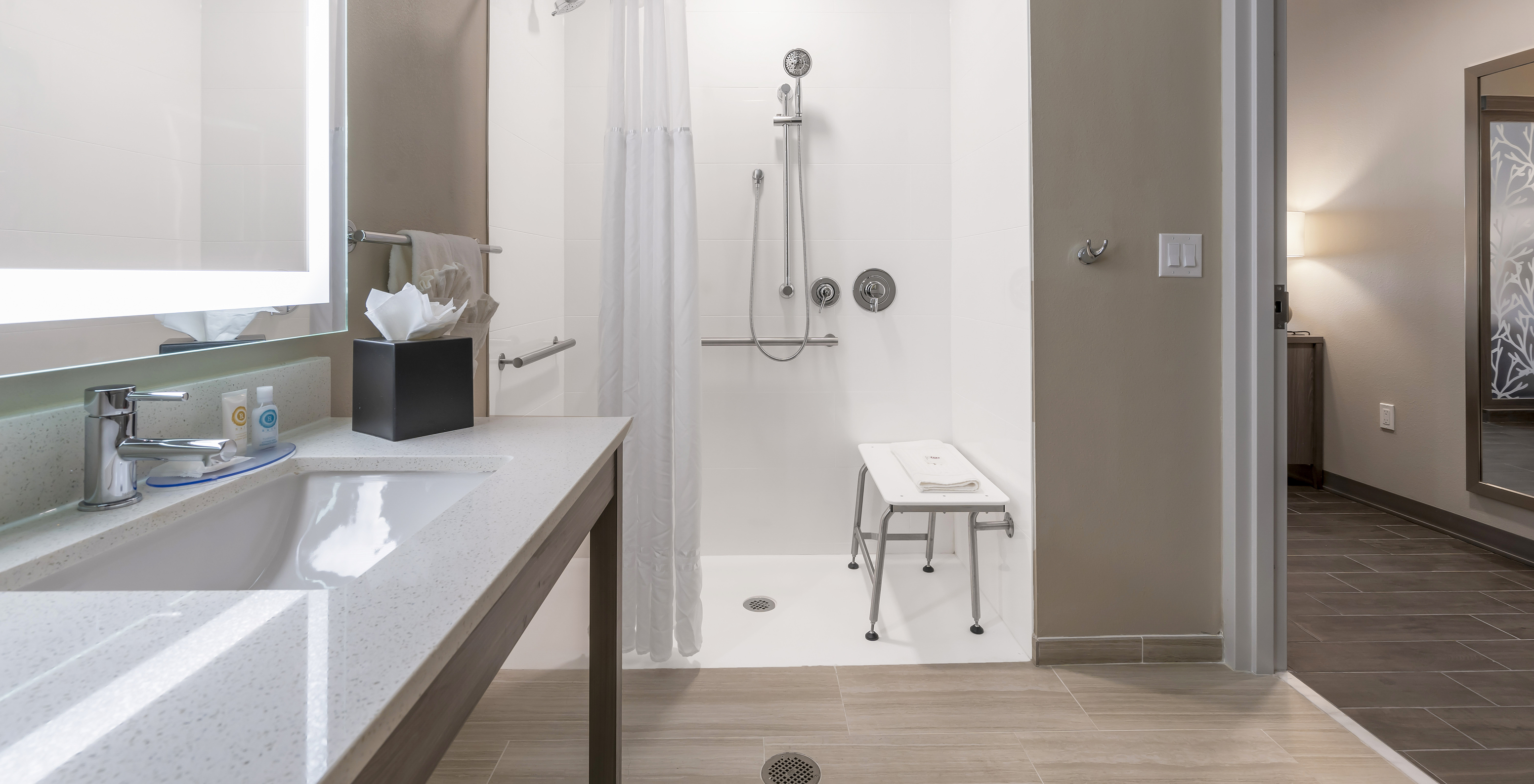 A Suite ADA King do Pestana Orlando Suites Lake Buena Vista com casa de banho com chuveiro adaptado, lavatório e espelho