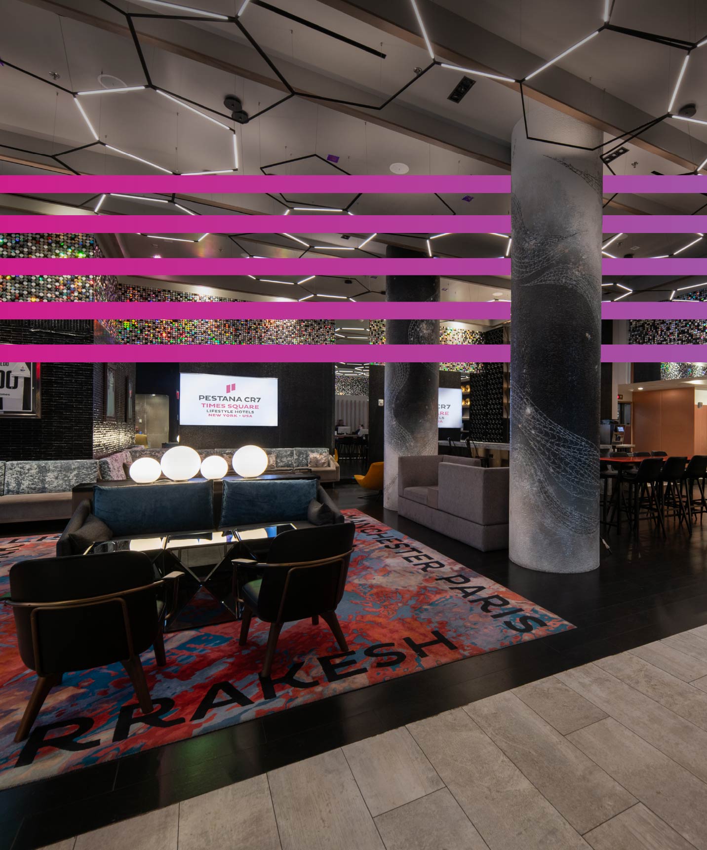 Pestana CR7 Times Square hotel com lounge moderno, iluminação geométrica no teto e área de estar ampla