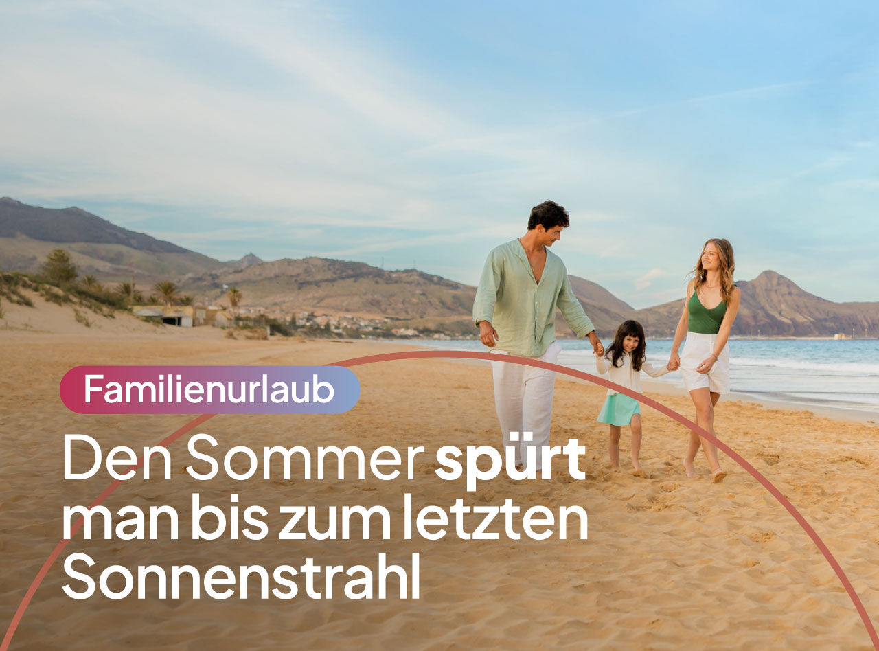 Familie spaziert bei warmem Licht entlang eines Sandstrands mit ruhigem Meer und Bergen im Hintergrund