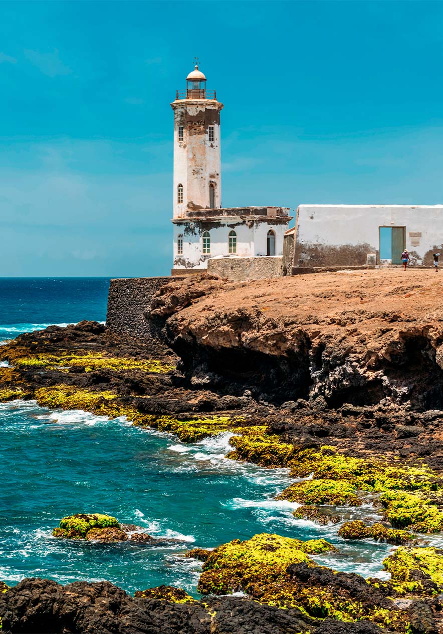 Leuchtturm in Kap Verde, auf felsigen Klippen mit blauem Meer im Hintergrund