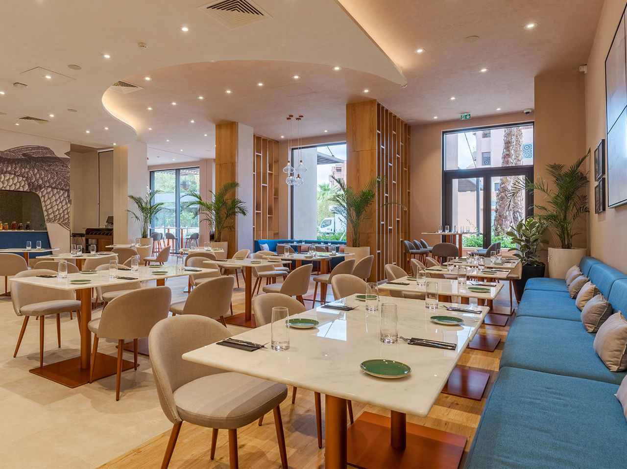 Das Restaurant Brasserie im Hotel im Zentrum von Marrakesch hat mehrere Tische, moderne Dekoration und Tageslicht