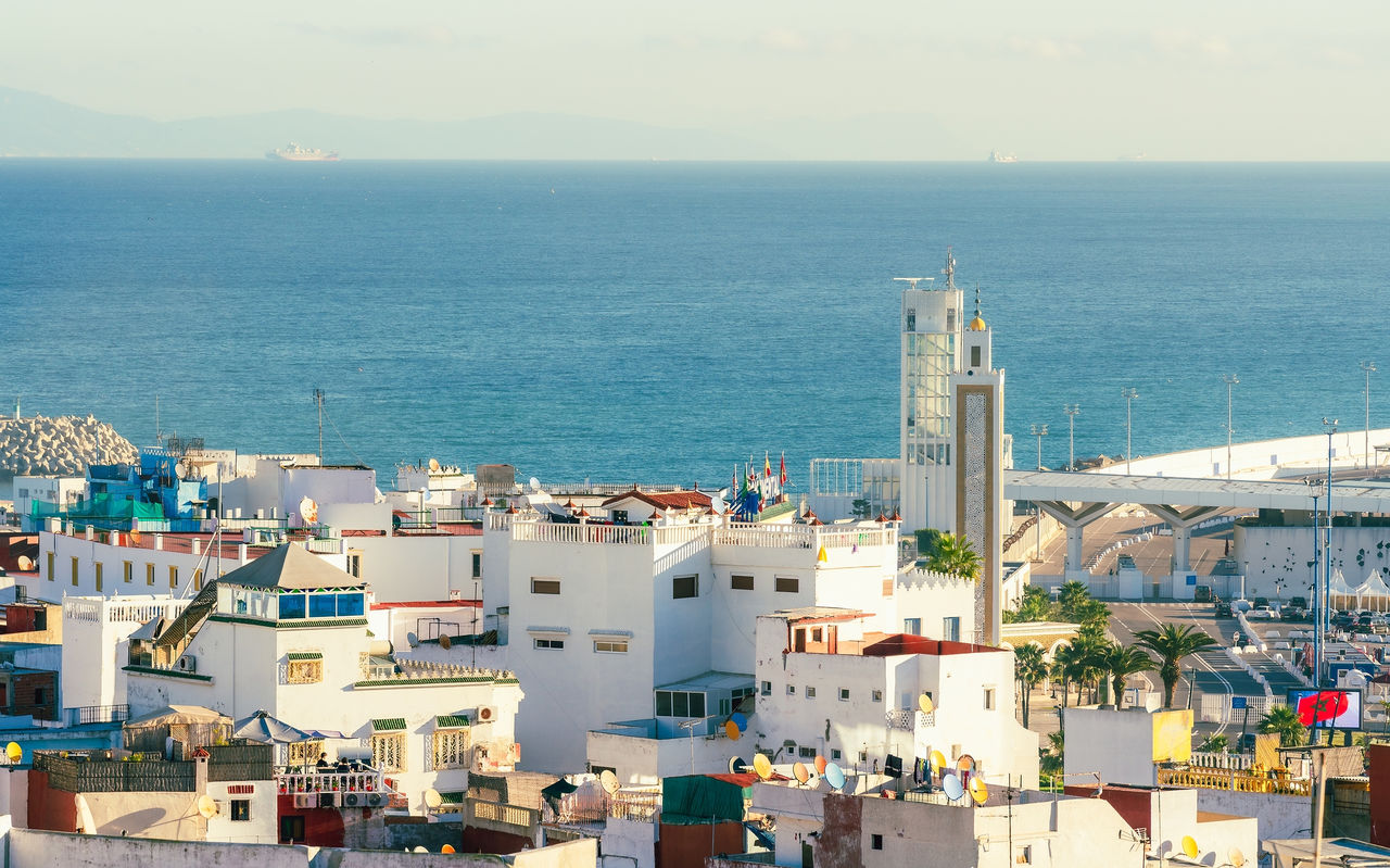 Blick auf Tanger mit weißen Gebäuden, traditioneller Architektur und dem Meer im Hintergrund