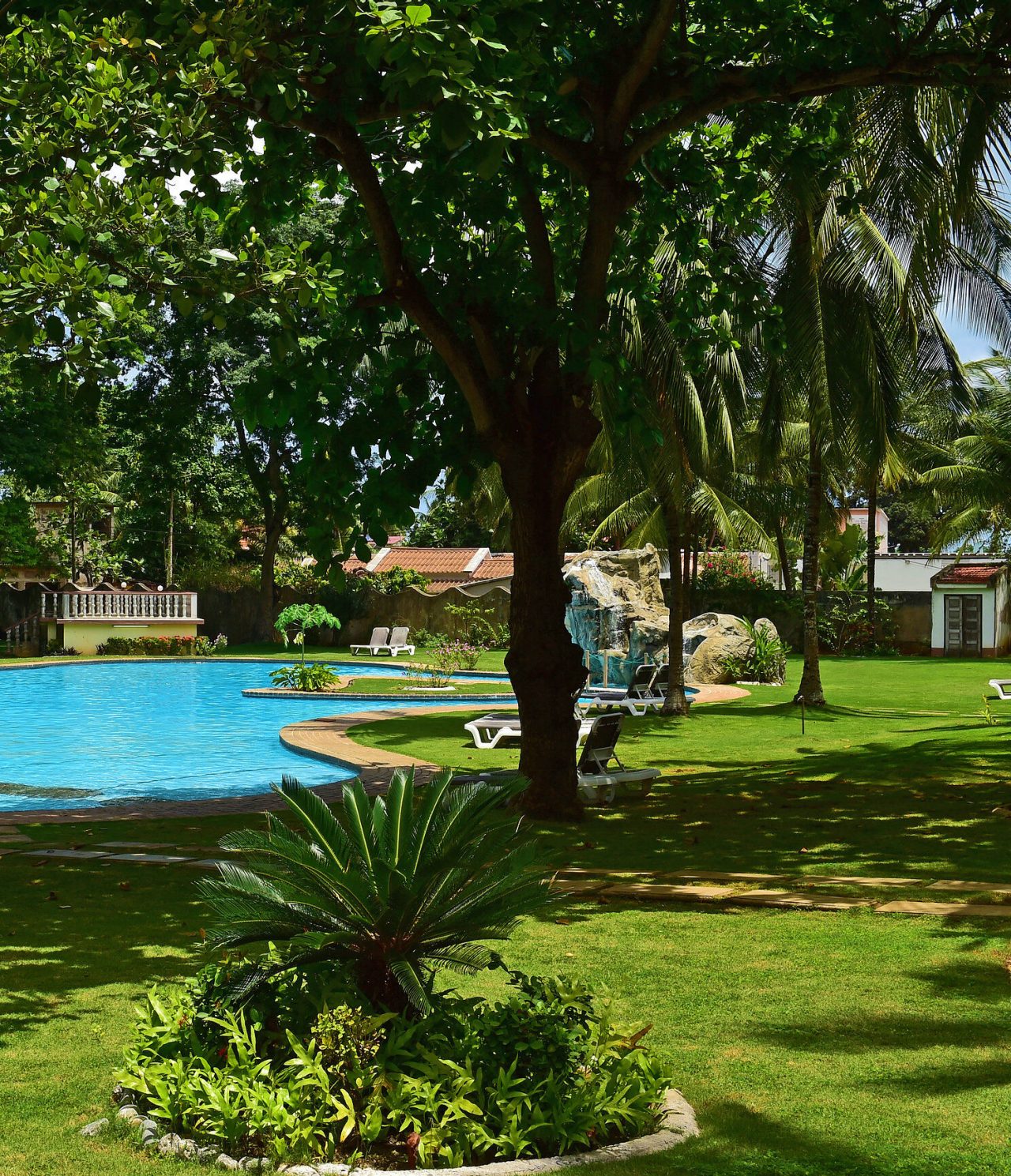 Die Bar Passante im 4-Sterne-Hotel in São Tomé hat einen Pool mit Liegen und Gras