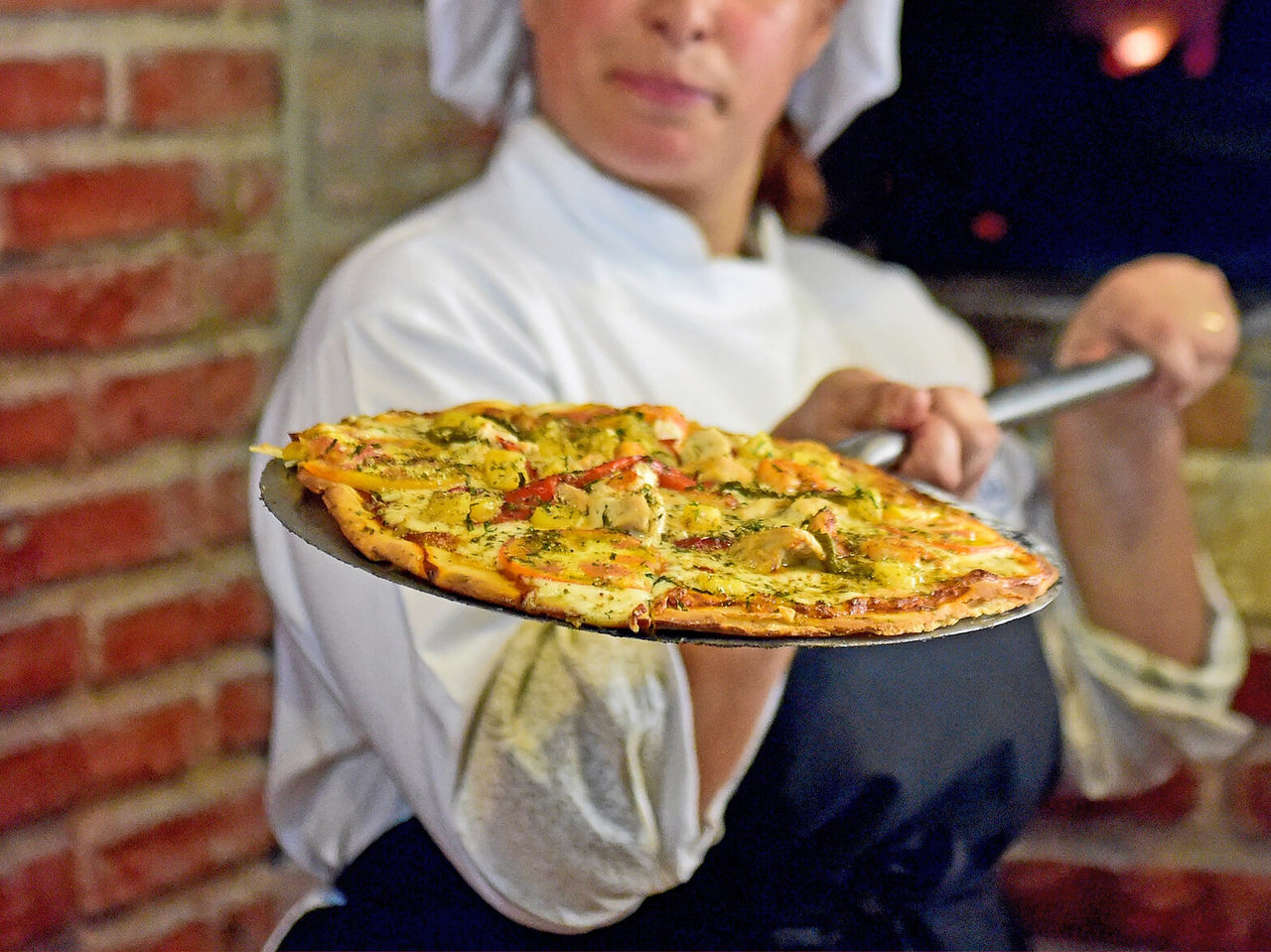 Das Restaurant Le Baron im 4-Sterne-Hotel in São Tomé hat eine Köchin, die Pizza mit Käse und Pilzen macht