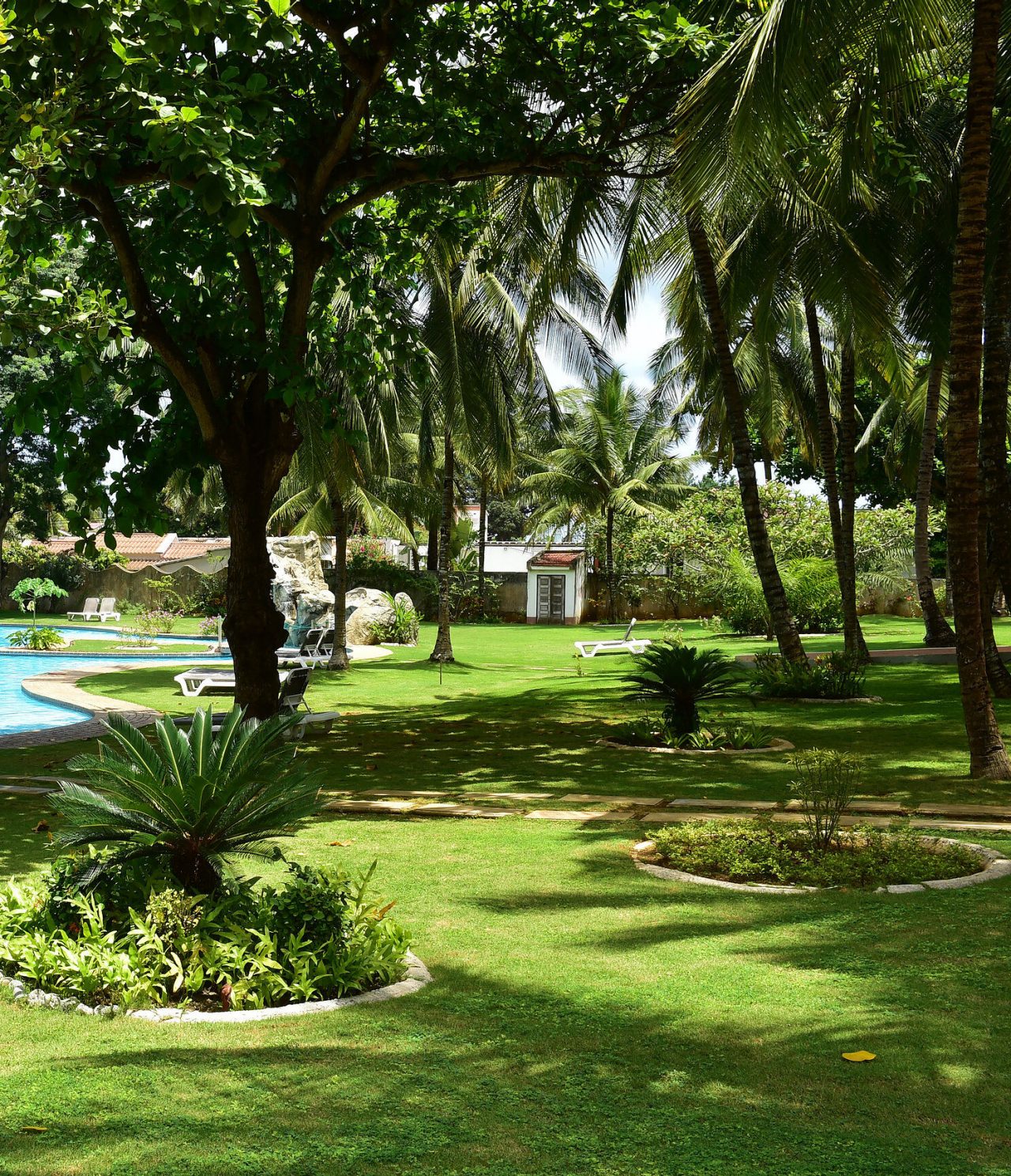 Die Bar Safu im 4-Sterne-Hotel in São Tomé hat einen Garten mit mehreren Bäumen und einem Pool