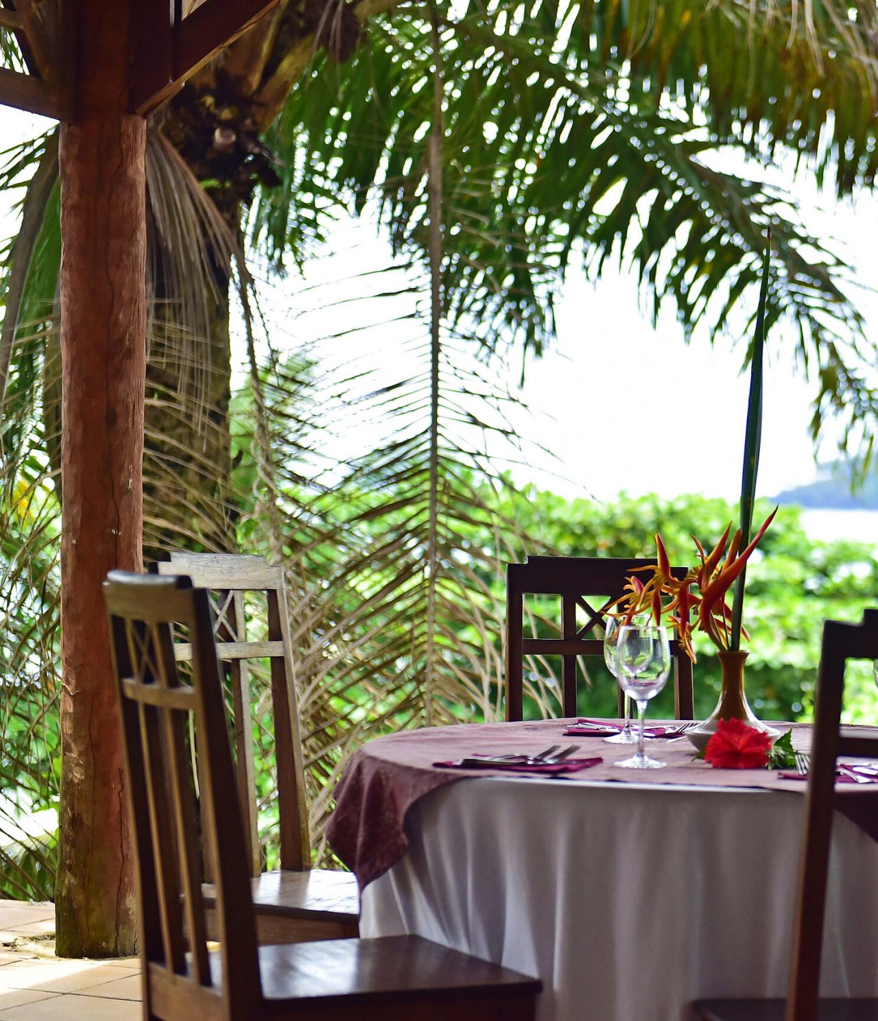 Das Restaurant 7 Pedras im Hotel im Ilhéu das Rolas, São Tomé, hat einen runden Tisch mit Stühlen und Blick auf die Insel