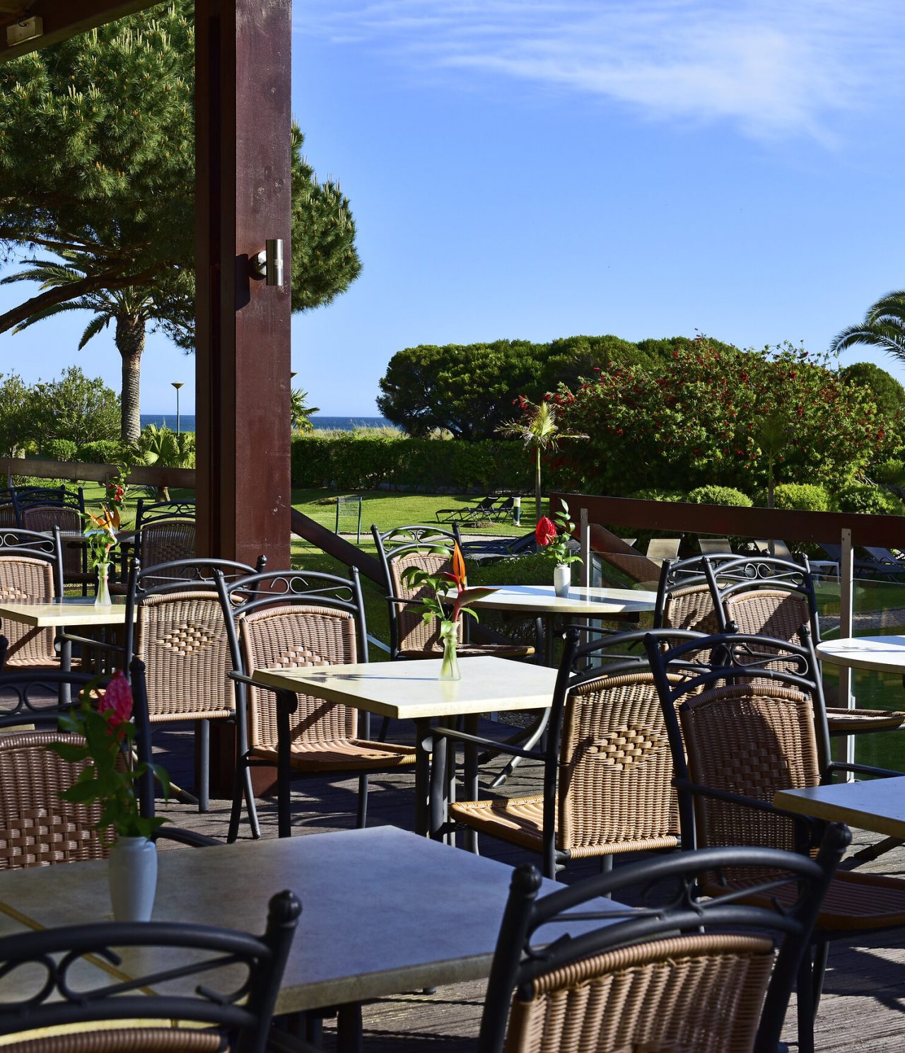 Das Restaurant Pavilhão do Rei im 4-Sterne-Hotel im Algarve hat eine Terrasse mit mehreren Tischen und Gartenblick