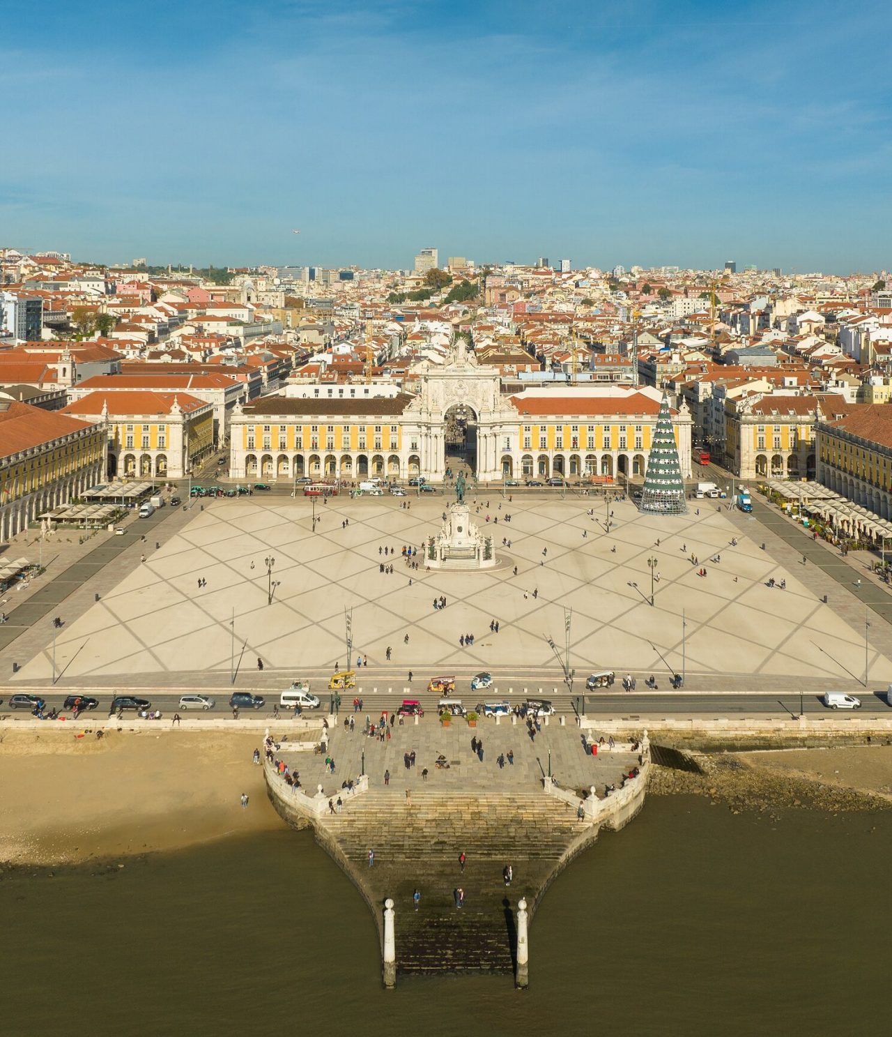 Luftaufnahme der Praça do Comércio in Lissabon, mit dem Tejo vor, der Statue in der Mitte und einem Weihnachtsbaum