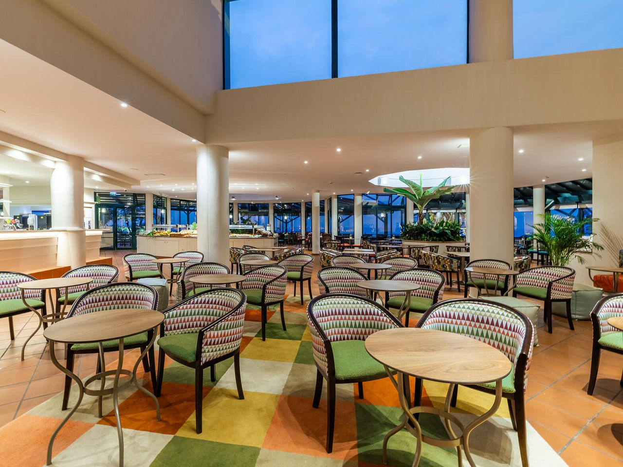 Die Arlequim Bar im 5-Sterne-Hotel in Funchal, Madeira hat Stühle mit runden Tischen und kariertem Teppich