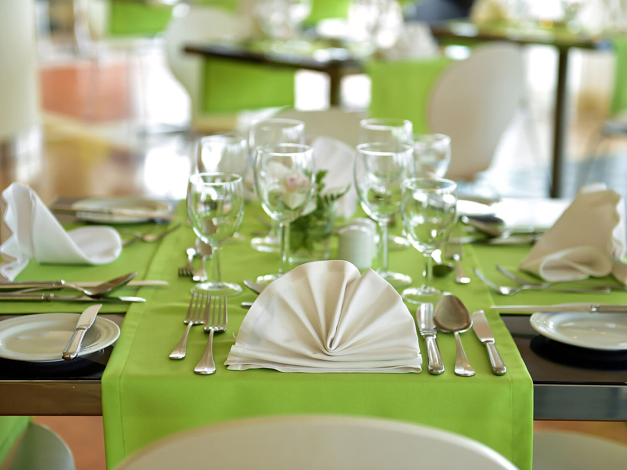 Das Restaurant Breezes im 4-Sterne-Hotel am Meer in Funchal hat elegante Tische mit grünen Tischdecken