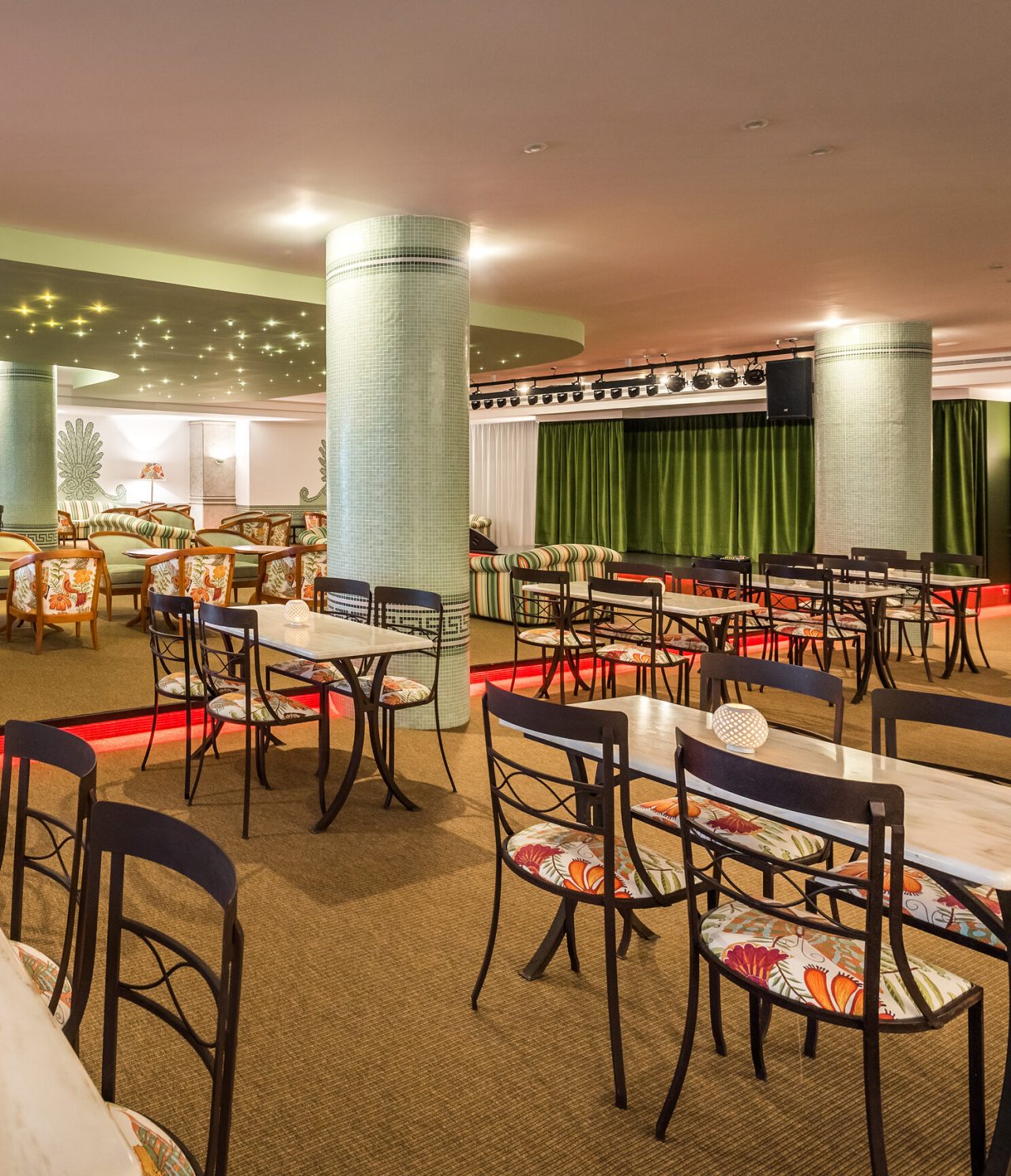 Die Bar Primavera Bar & Lounge im 5-Sterne-Hotel in Funchal hat einen großen Innenbereich mit grünen Säulen und Tischen