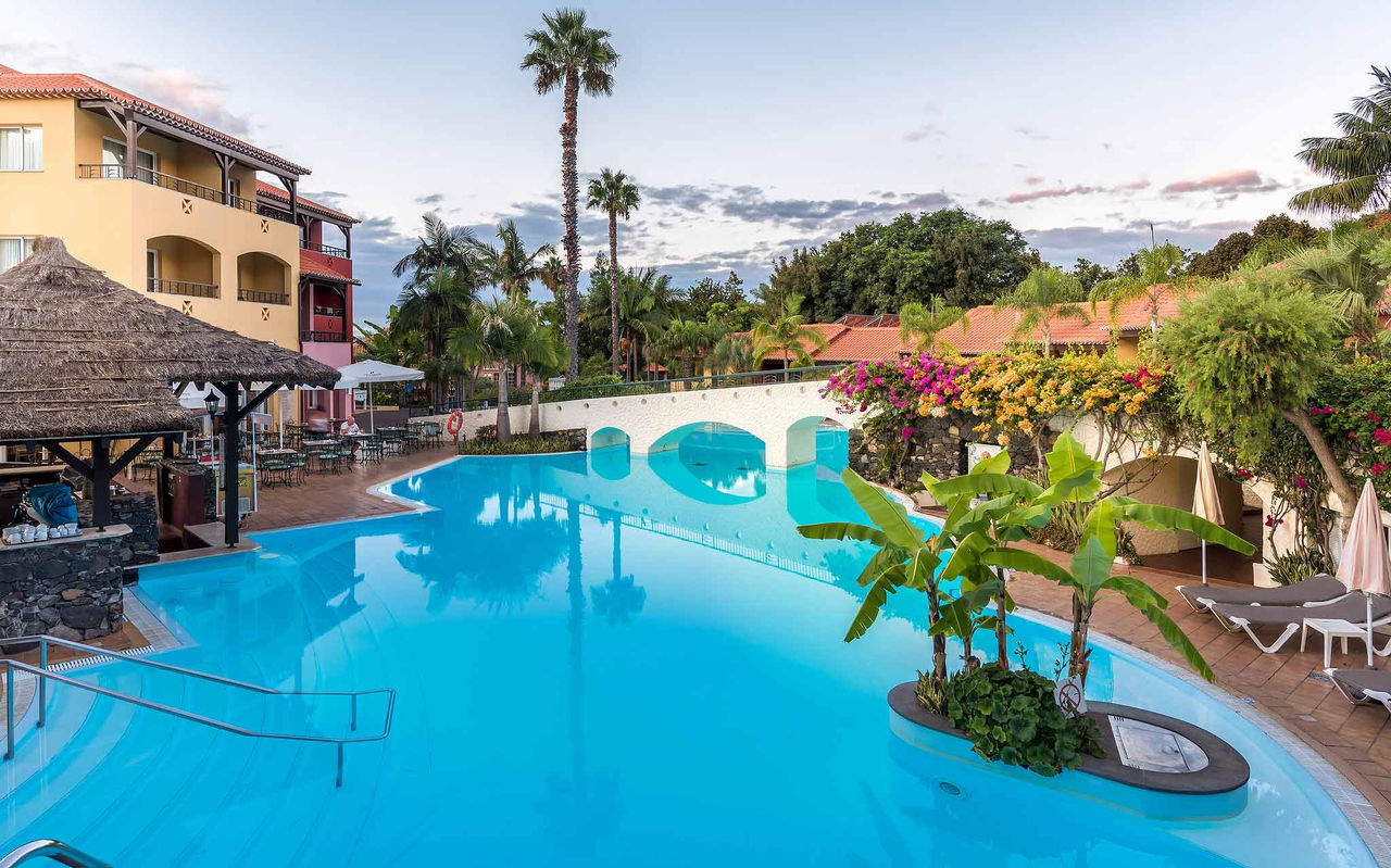 Außenpool umgeben von tropischen Pflanzen und Bäumen im Pestana Village, einem romantischen Hotel in Funchal, Madeira