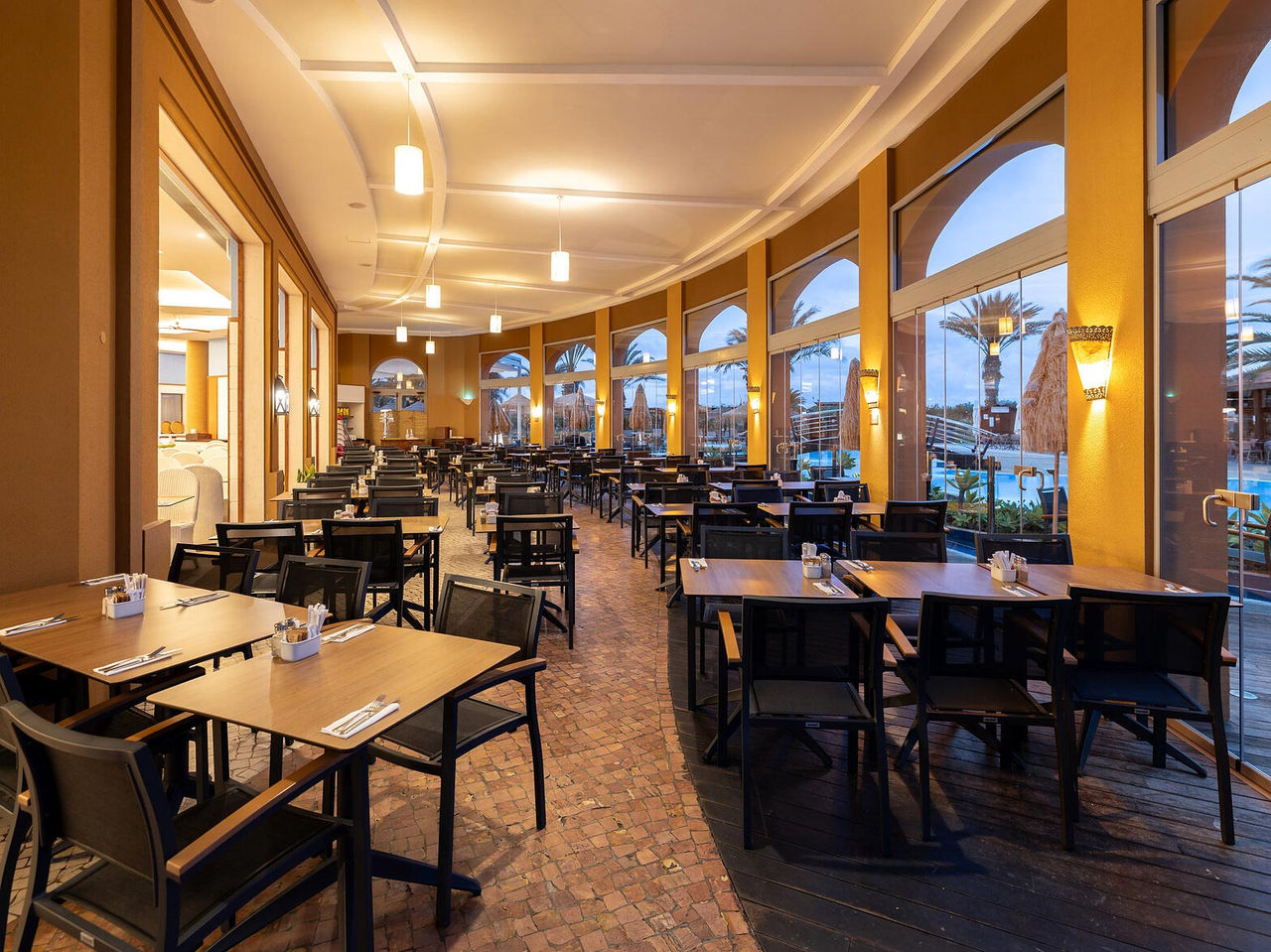 Das Restaurant Marés im 5-Sterne-Resort auf Porto Santo hat einen großzügigen Raum mit gelben Wänden und grünen Stühlen.