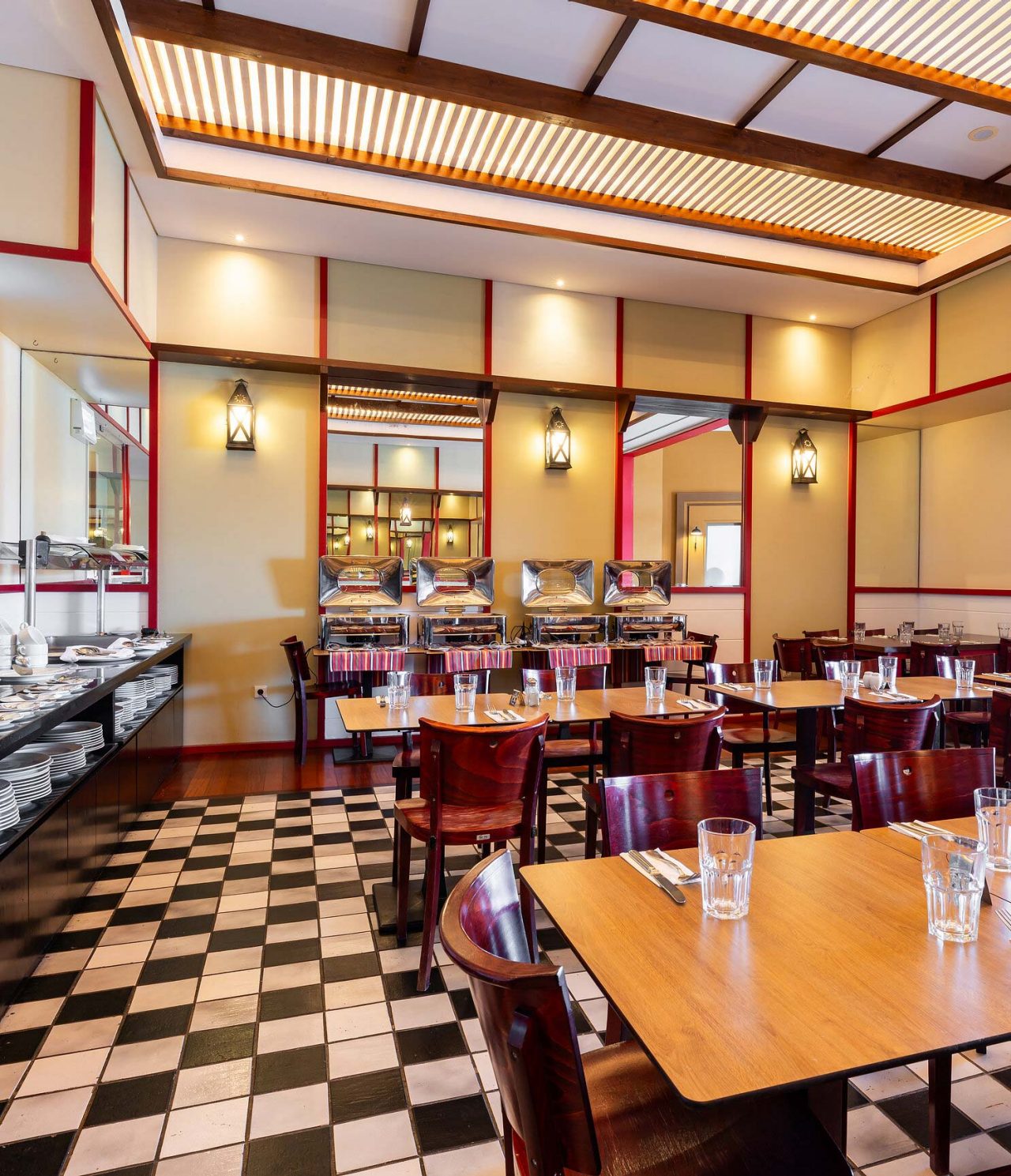 Das Restaurant Luigi im 5-Sterne-Resort auf Porto Santo hat dunkle Tische und Stühle mit roten Akzenten.