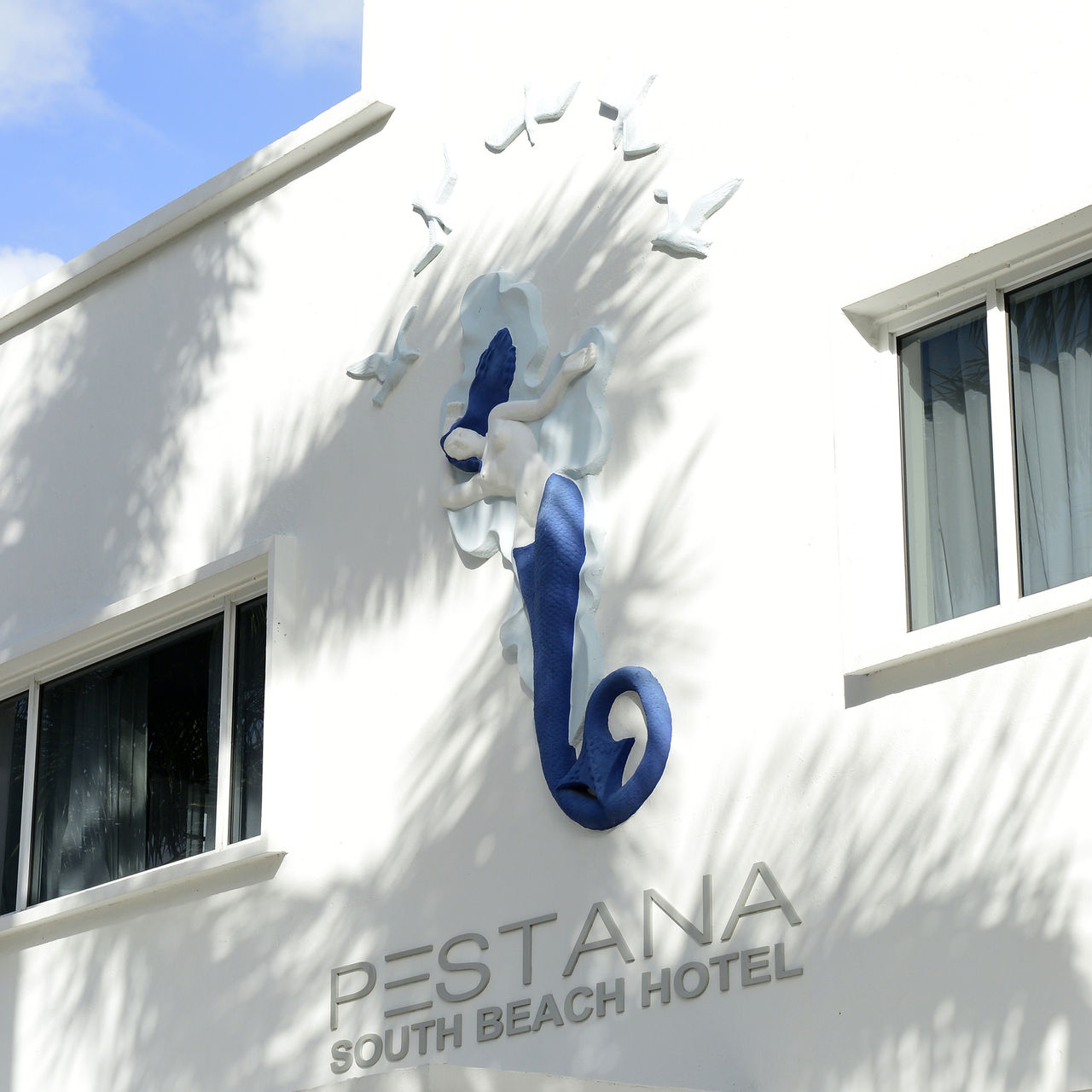 Fassade des Pestana Miami South Beach Hotels mit einer markanten Skulptur einer Meerjungfrau und der Nummer 1831